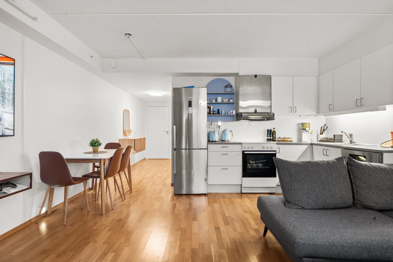 Delikat stue- og kjøkkenløsning som gir en sosial og funksjonell romfølelse. Galleribilde