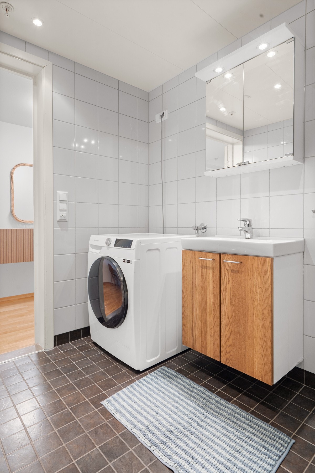 Delikat bad med flislagte overflater, speilskap med overskap, servantmøbel med god oppbevaringsplass og dusjløsning i herdet glass. Gulvvarme og ventilasjon gir økt komfort i hverdagen. Galleribilde