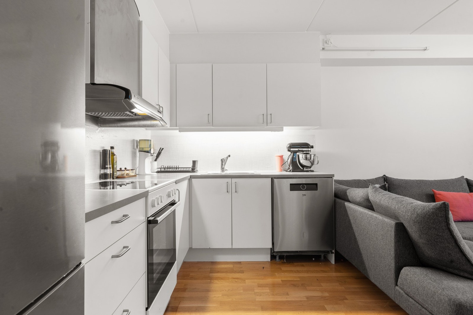 Funksjonelt kjøkken med slette fronter og laminerte skrog. Laminat benkeplate med nedfelt oppvaskkum, tilrettelagte nisjer for komfyr, oppvaskmaskin og kjøl-/fryseskap. Galleribilde