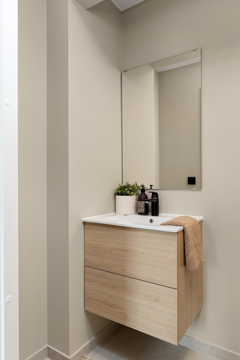 Praktisk ekstra toalettrom med flis på gulv og høy standard. Toalett og servant. Galleribilde