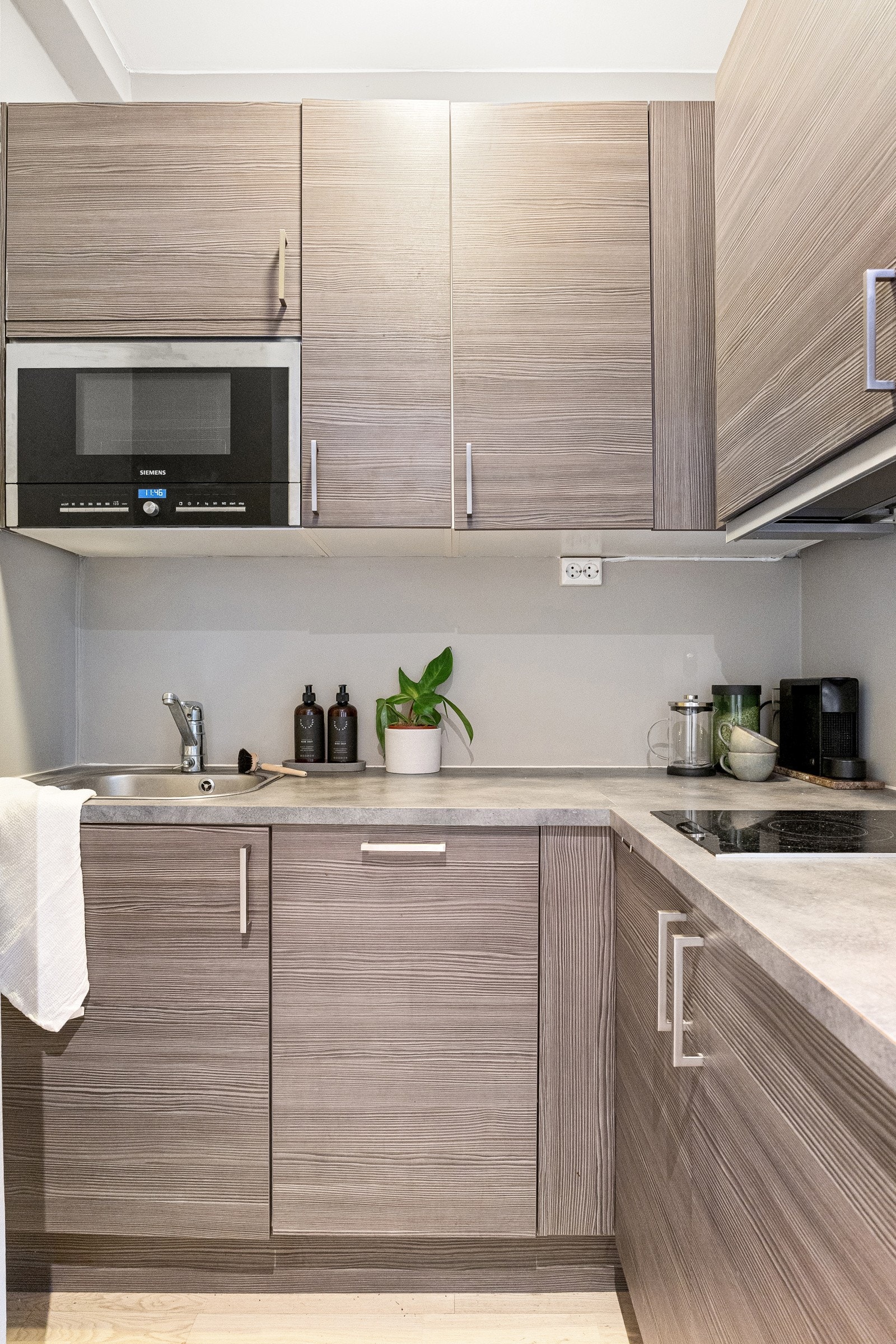 Kjøkkeninnredningen byr på glatte, folierte fronter og slitesterk benkeplate i laminat. Galleribilde