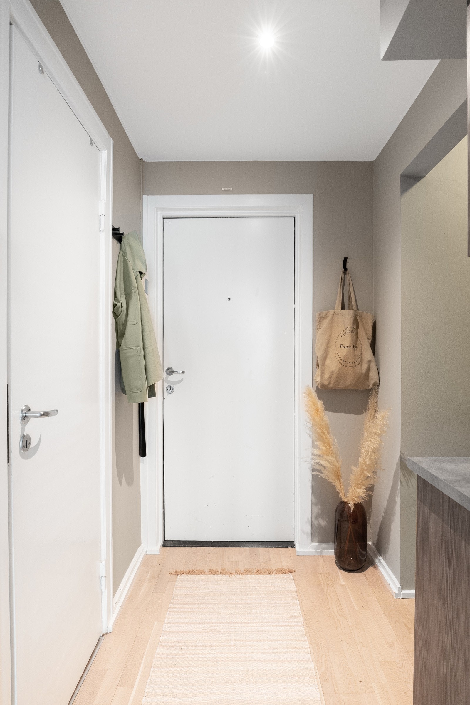 Allerede i entreen får man et godt inntrykk av leilighetens moderne og velvalgte innredning. Det er god plass til plassering av sko, samt oppheng av jakker. Galleribilde