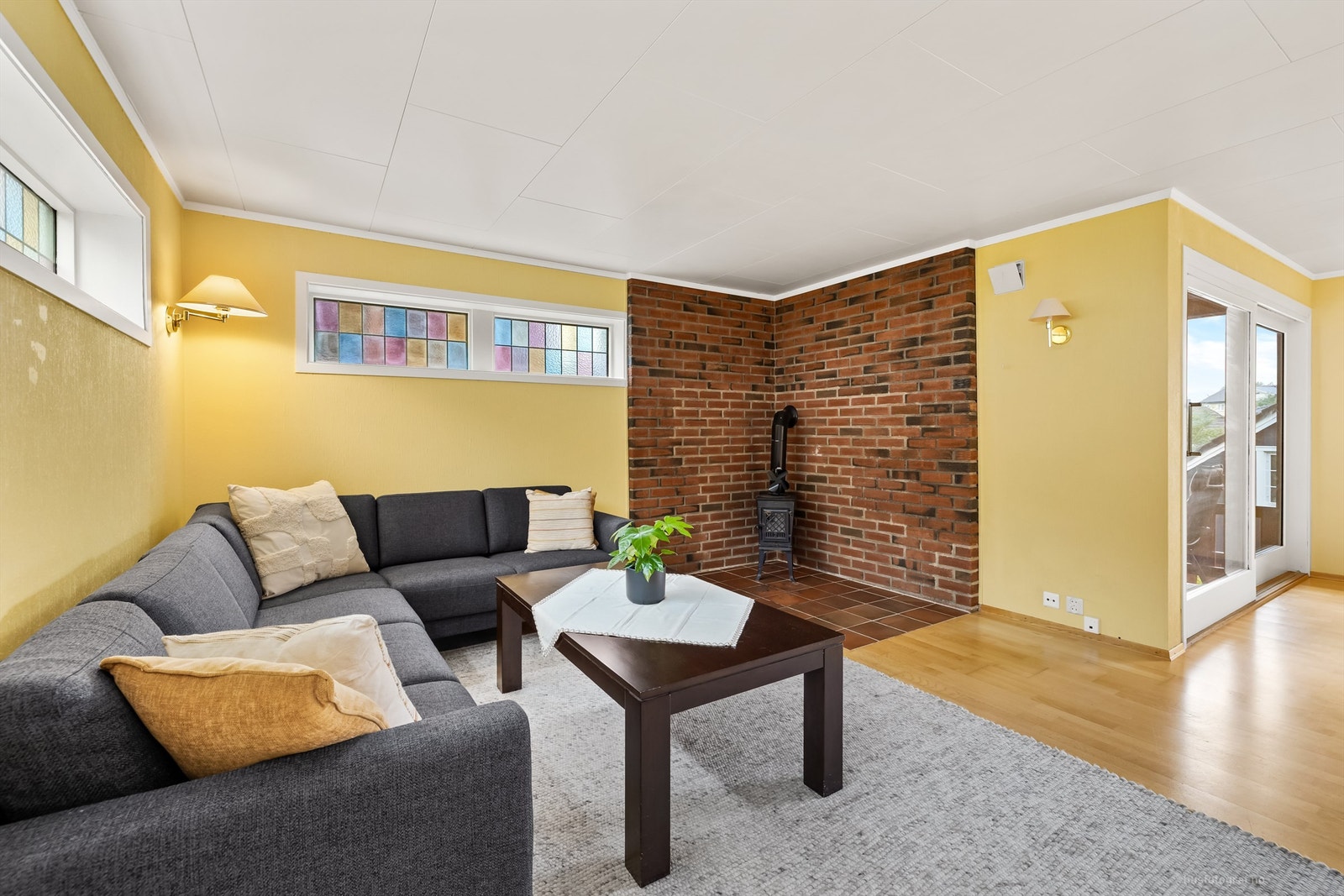 Frittstående vedovn i hjørne med fliser på gulv og murvegger Galleribilde