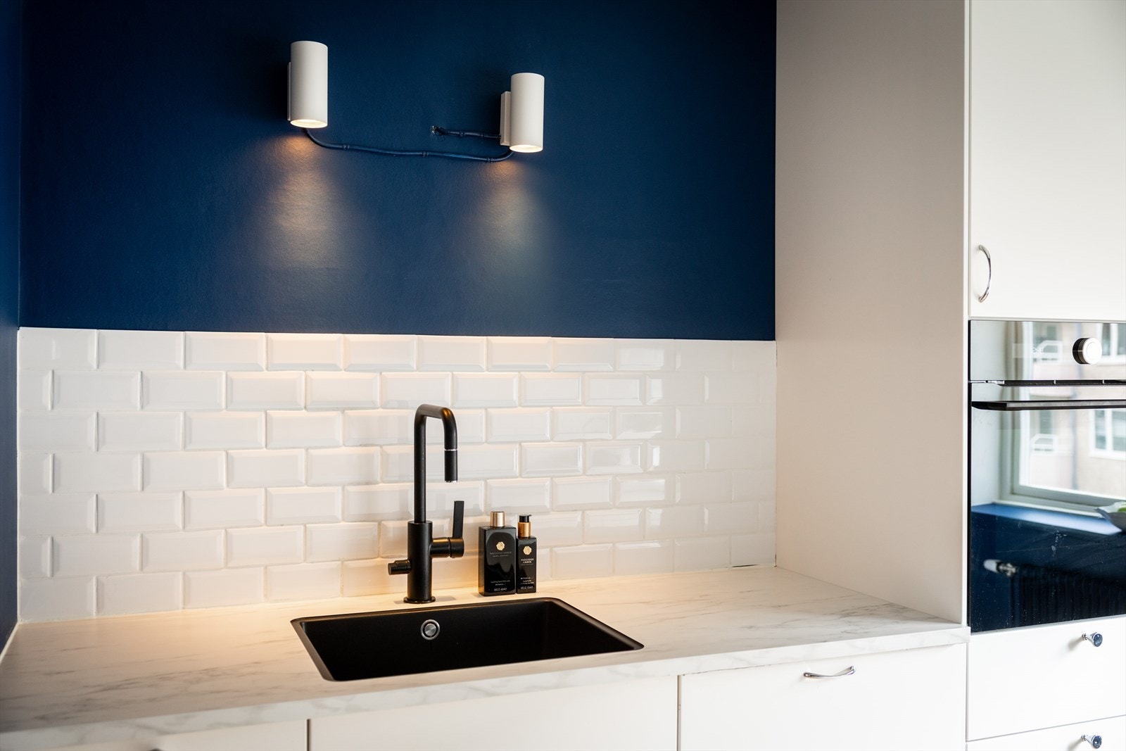 - Moderne kjøkkeninnredning med glatte fronter, laminat benkeplate, planlimt vaskekum og fliser over benkeplaten - Galleribilde