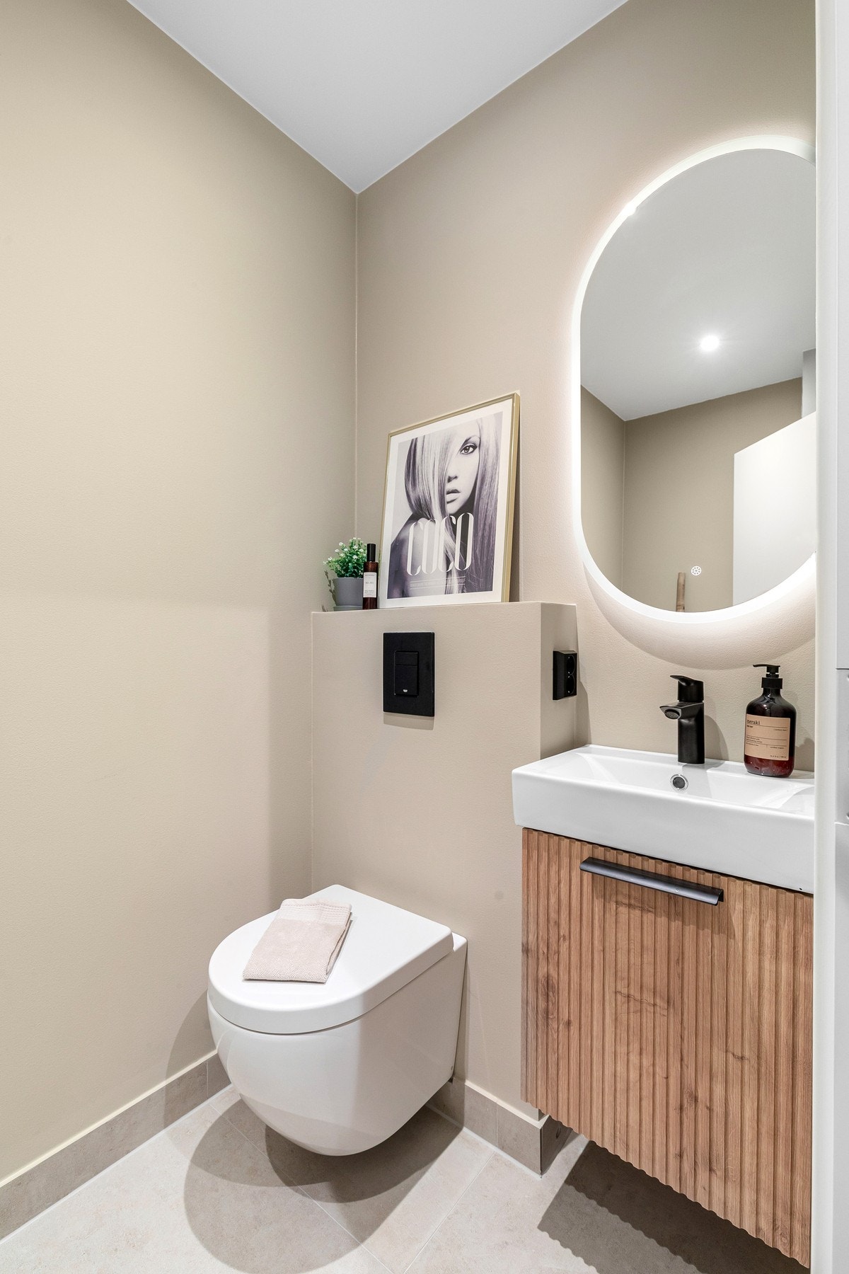 Separat toalettrom med veggmontert toalett og opplegg for vaskemaskin. Galleribilde