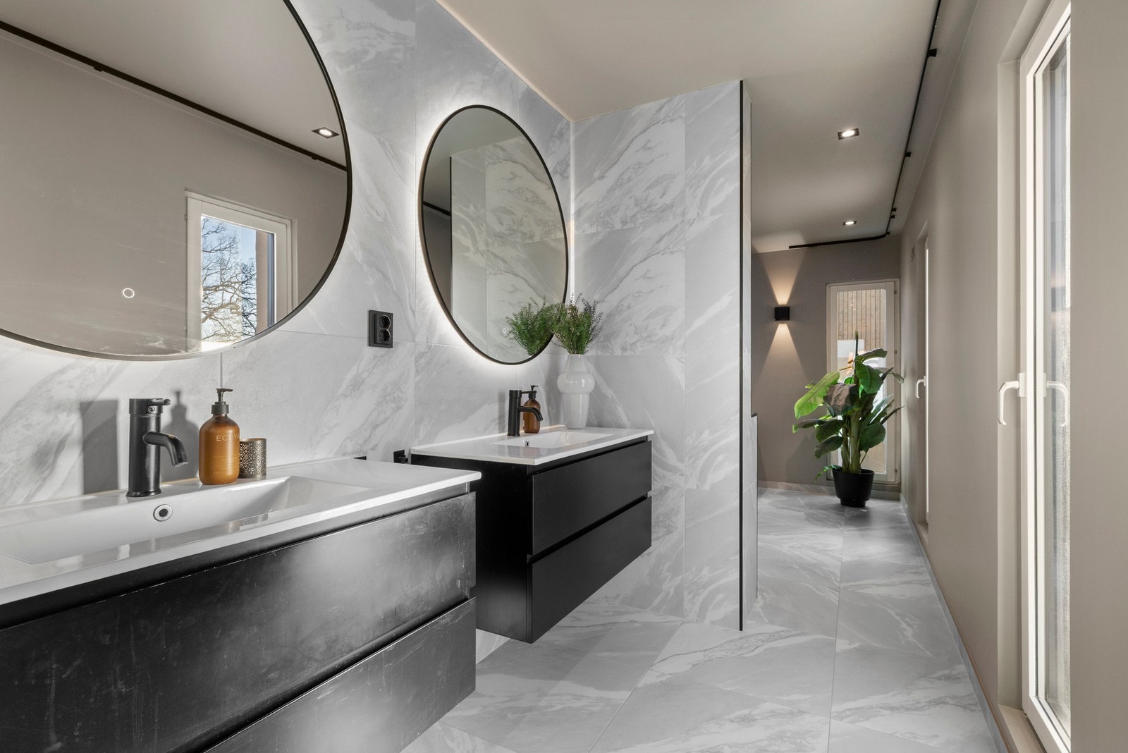 Tilknyttet hovedsoverommet ligger et moderne bad med flislagte overflater, dobbel servant og vegghengt toalett. Galleribilde