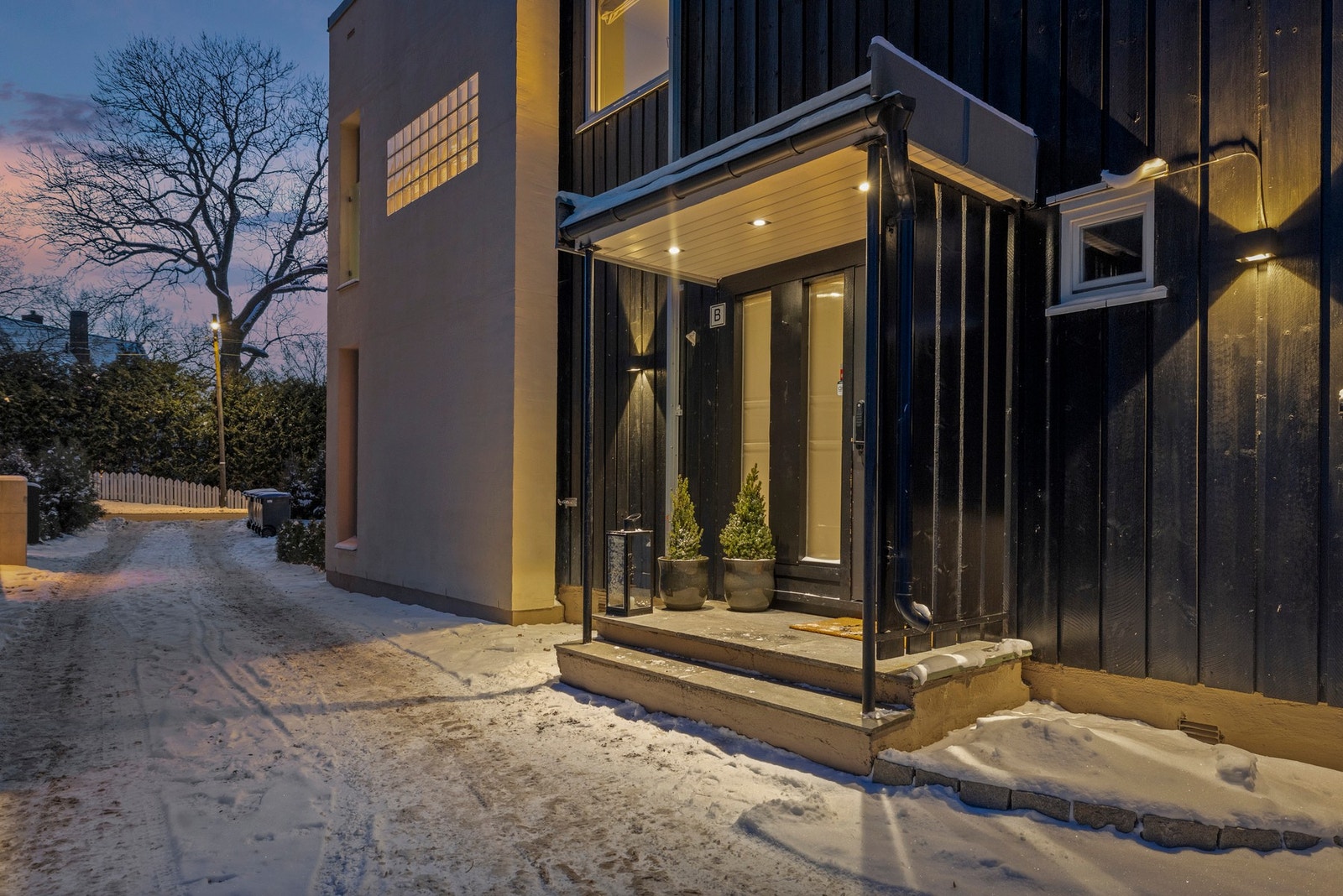 Boligen ønsker velkommen via et overbygget inngangsparti med innfelte spotter i himlingen, som gir et stilrent og gjennomført førsteinntrykk. Galleribilde