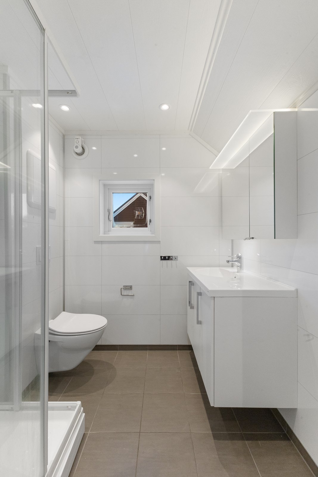 Badet på loftet er fra 2015, har varmekabler i gulv, veggmontert wc med trykkbetjening, downlights i himling og romslig innredning. Galleribilde