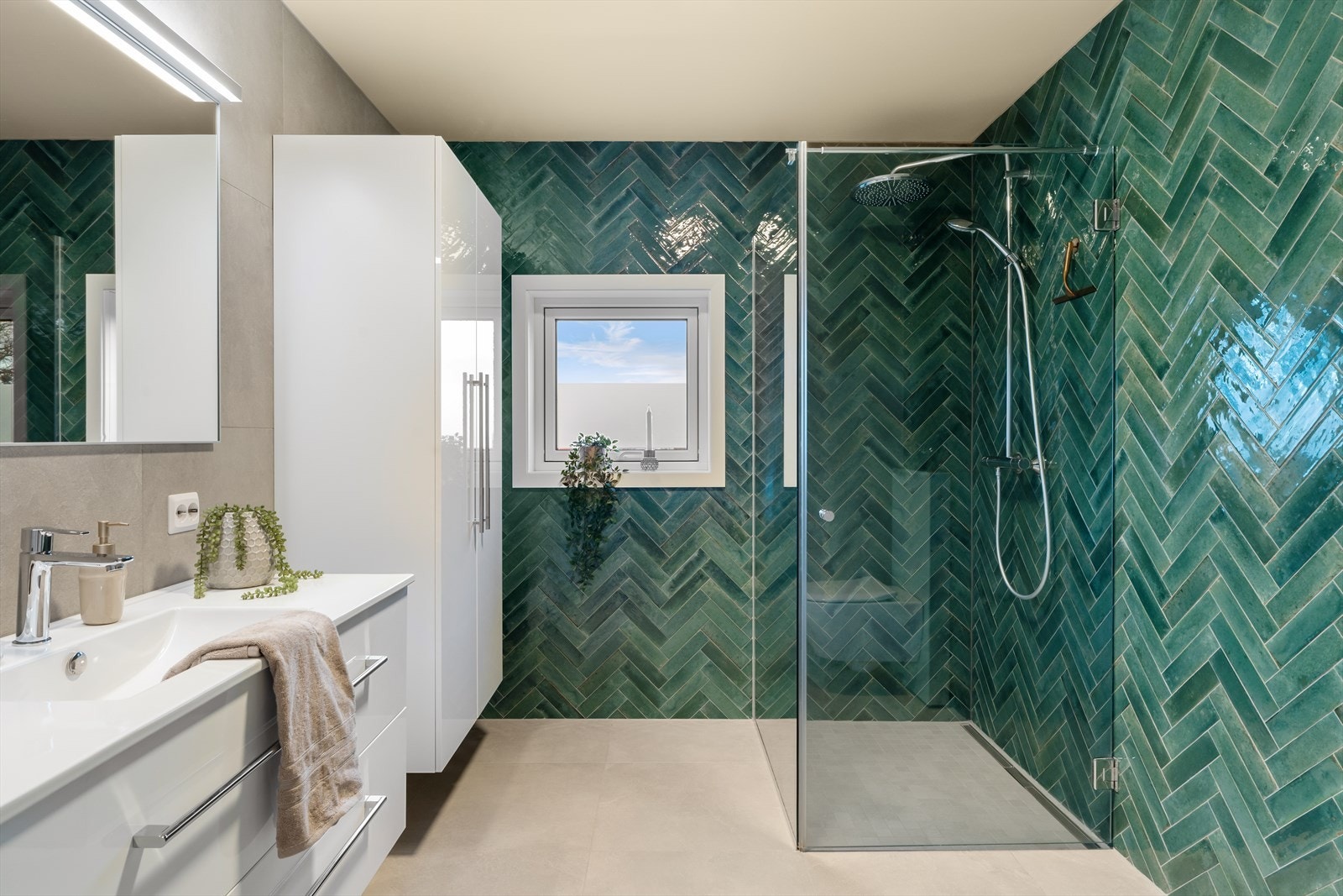 Moderne, helfliset bad med gulvvarme, vegghengt toalett, dusjnisje og vask i møbel Galleribilde