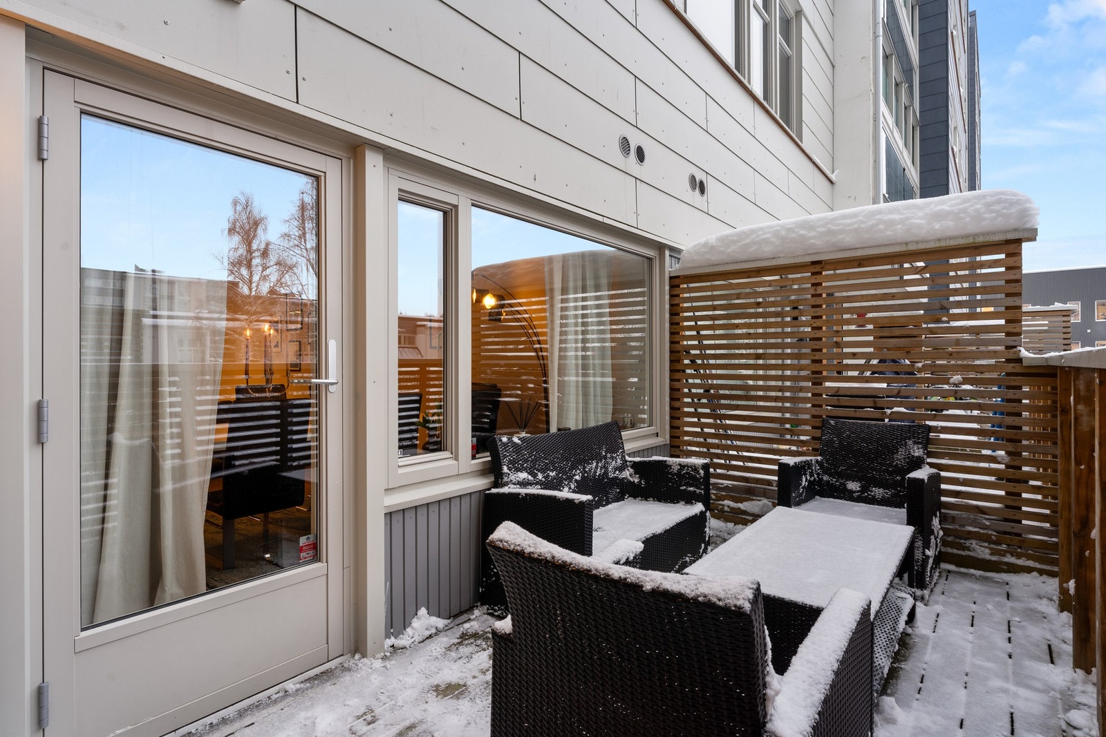 Privat terrasse med levegger og utgang direkte fra stue - et naturlig samlingspunkt som forlenger boligens oppholdsareal. Galleribilde