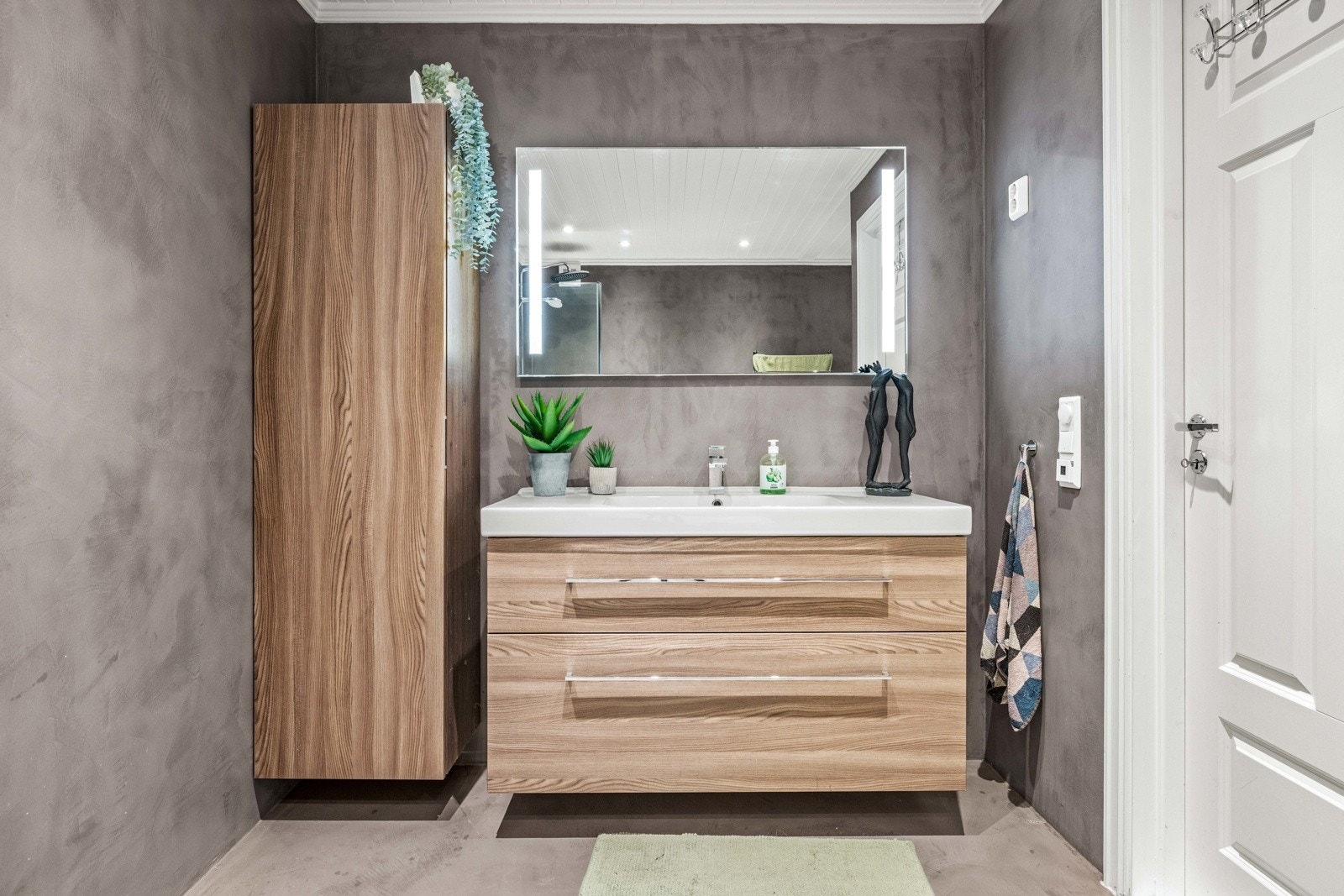 Stilren innredning i eikefiner med tilhørende høyskap. Galleribilde