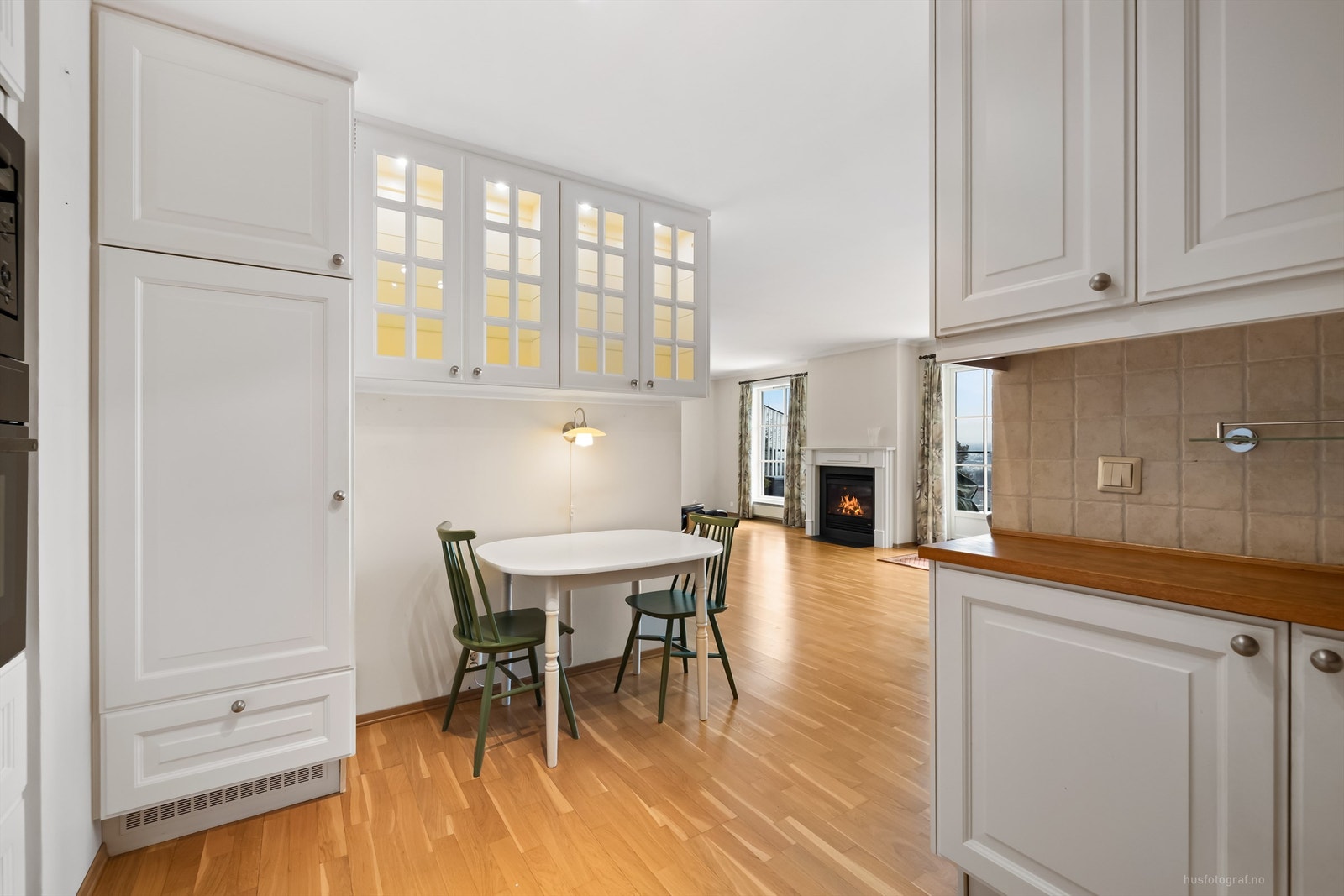 Flislagte felt over benkeplater av tre og lysarmaturer under overskap Galleribilde