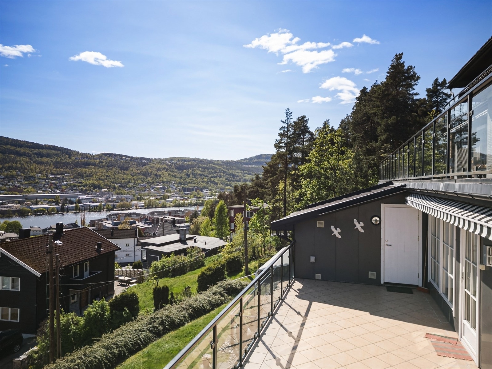 Sydvendt terrasse på 28 kvm med flislagt dekke, utvendig belysning, strømuttak og markise Galleribilde