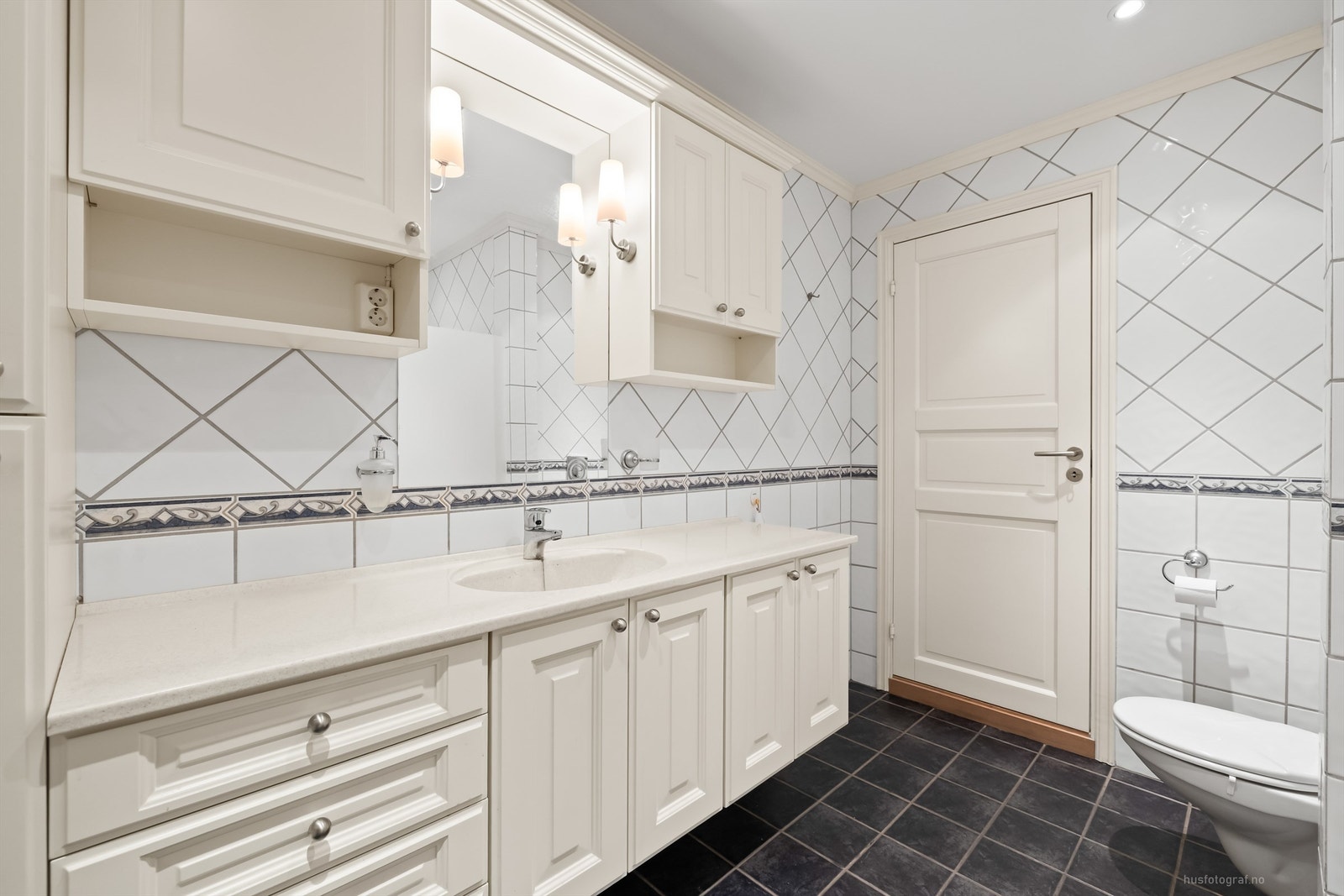 Romslig servantinnredning med vegghengte skap, høyskap og underskap Galleribilde