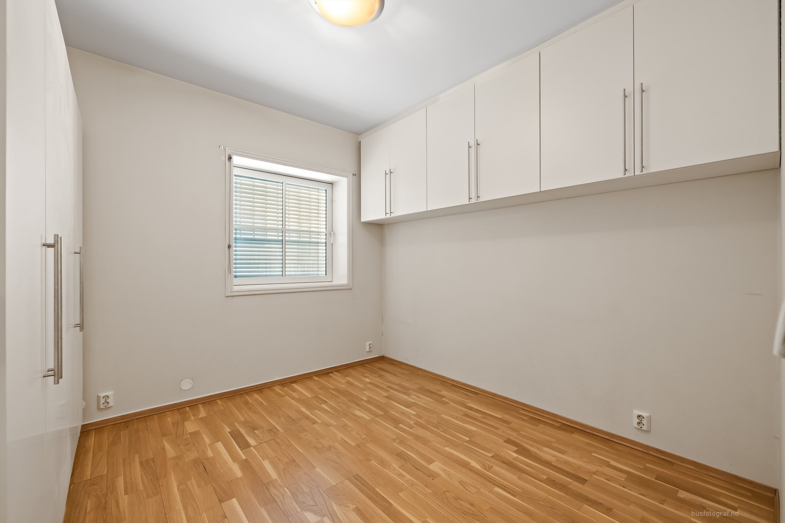 Soverom med garderobeskap og vegghengte overskap Galleribilde