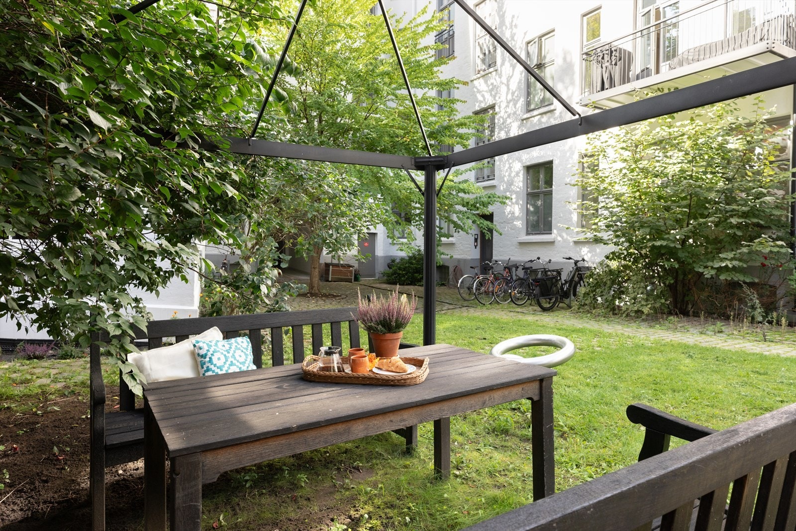 Frodig og hyggelig bakgård med sitteplasser. Galleribilde