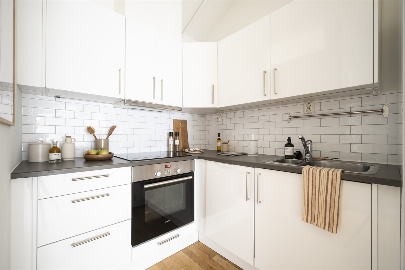 Kjøkken med glatte fronter og god plass til lagring i både over og underskap. Kjøkkenet er utstyrt med integrert platetopp, stekeovn, oppvaskmaskin samt kjøl fryseskap, og har avtrekk over kokeplass. Galleribilde