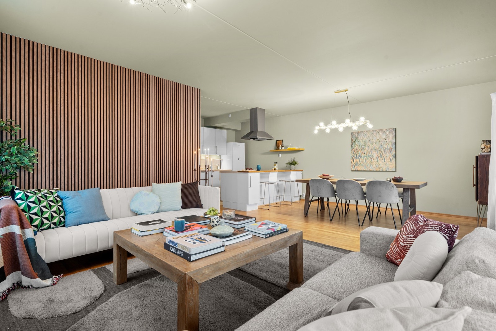 Lys og romslig stue i åpen løsning mot kjøkken og spiseplass. Galleribilde