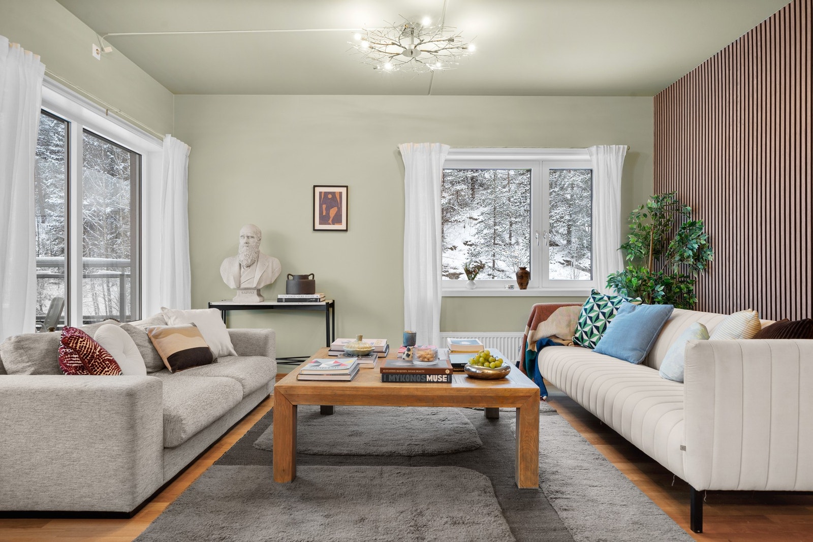 Innbydende stuesone med god takhøyde, store vindusflater og gjennomtenkte fargevalg som skaper en lun og harmonisk atmosfære. Galleribilde