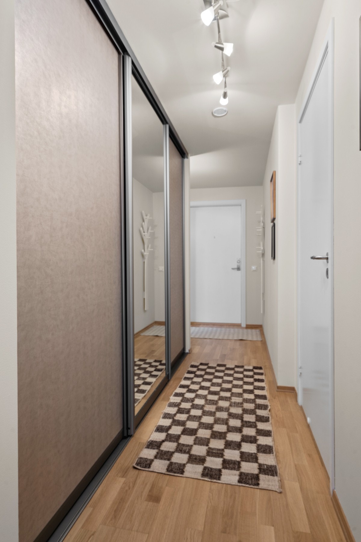 Romslig entré/gang med skyvedørsgarderobe som gir rikelig med oppbevaringsplass og et ryddig førsteinntrykk. Galleribilde