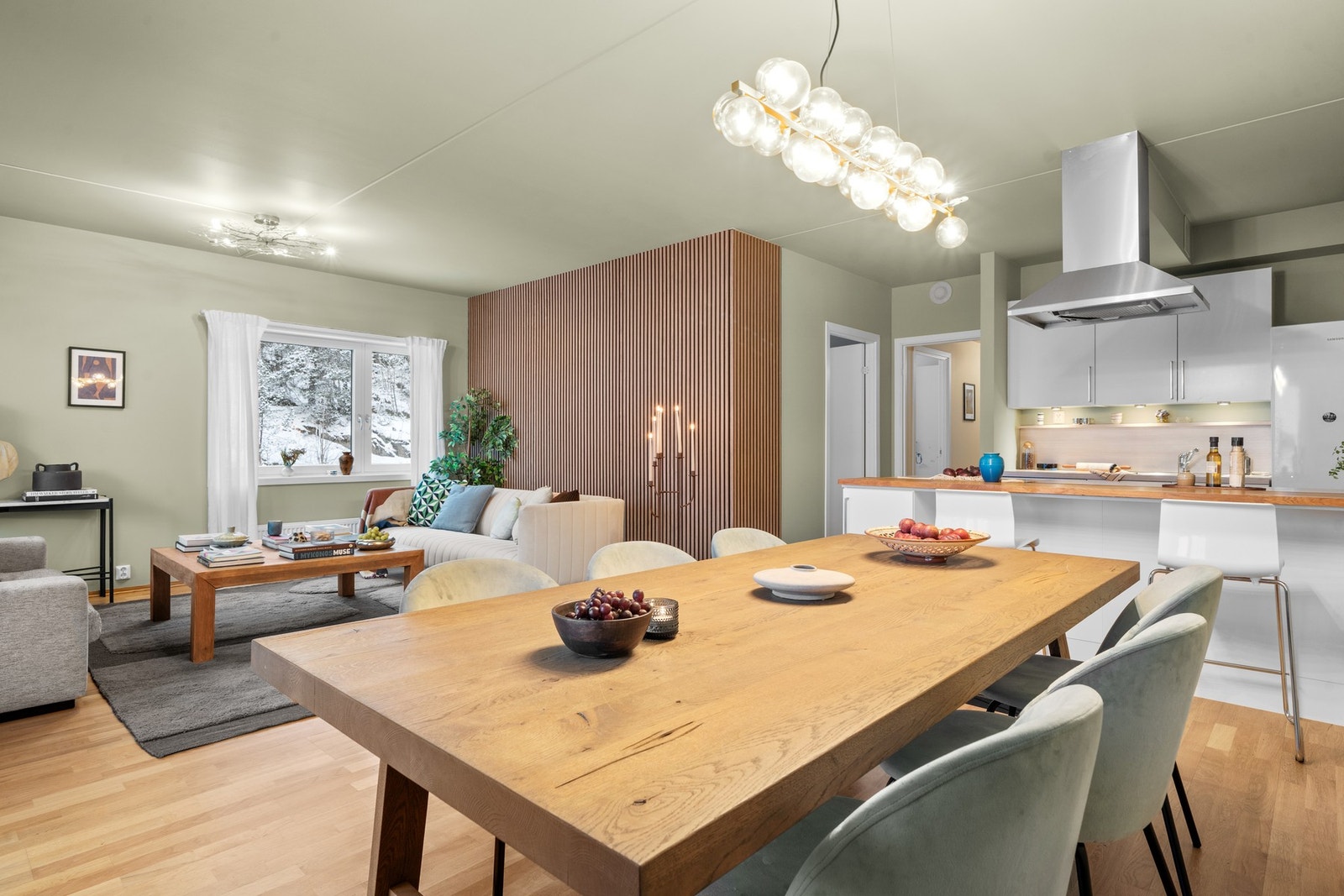 Stilren spiseplass med god plass til langbord, moderne belysning og åpen forbindelse mot både kjøkken og stue - perfekt for sosiale sammenkomster. Galleribilde