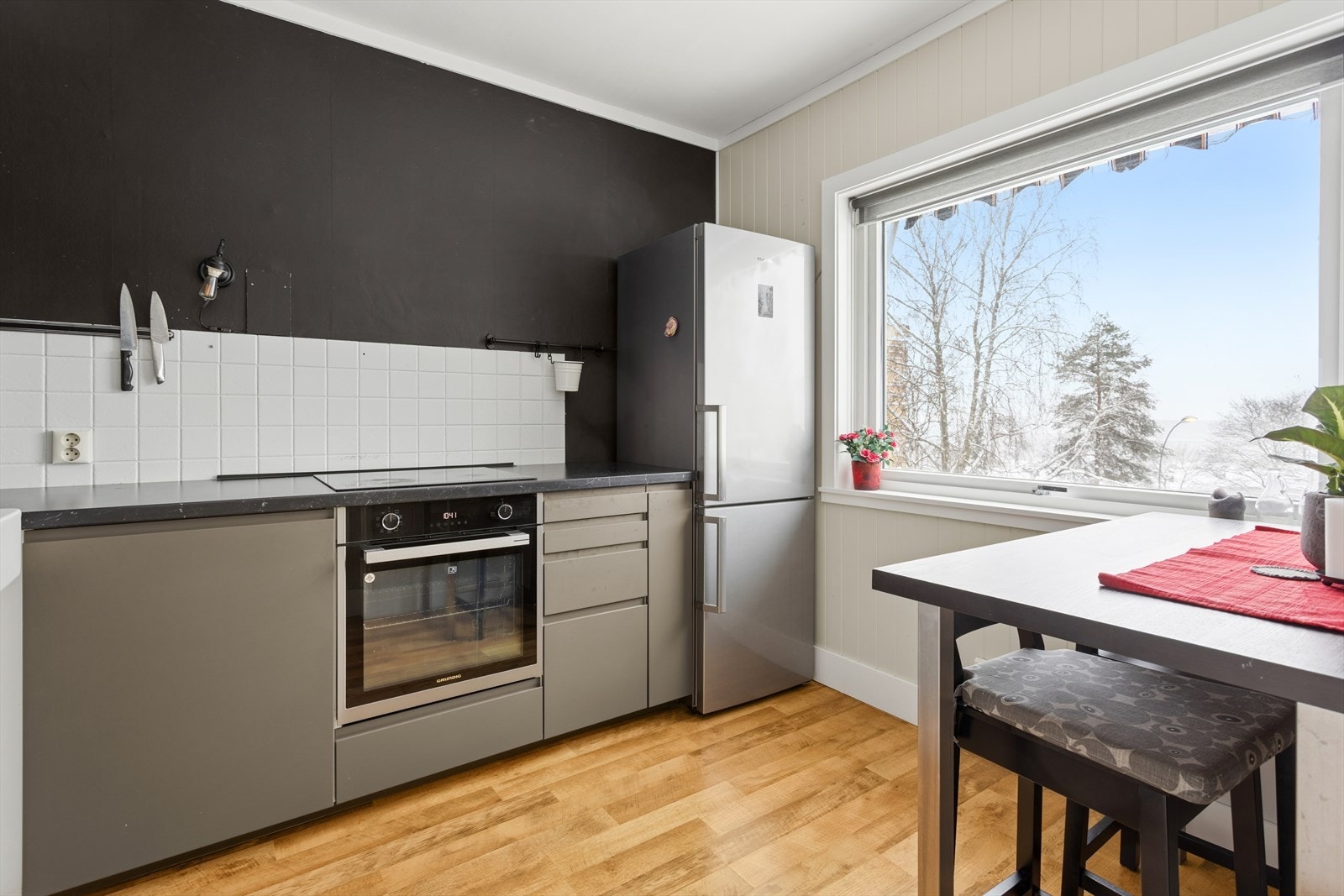 Kjøkkenet har opplegg for oppvaskmaskin og integrerte hvitevarer. Det er lagt fliser over benkeskap. Galleribilde