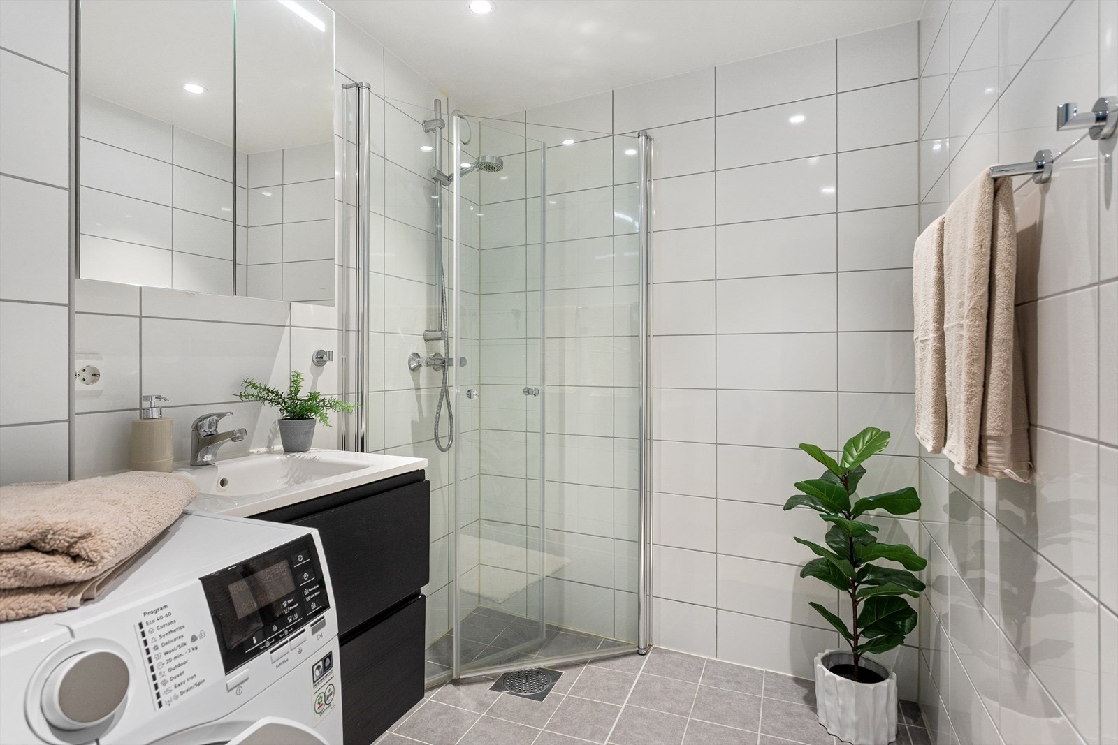 Pent flislagt bad fra 2021 i regi av borettslaget. Badet har varme i gulv, opplegg for vaskemaskin, toalett, speilskap, dusjhjørne og servant med innredning. Galleribilde