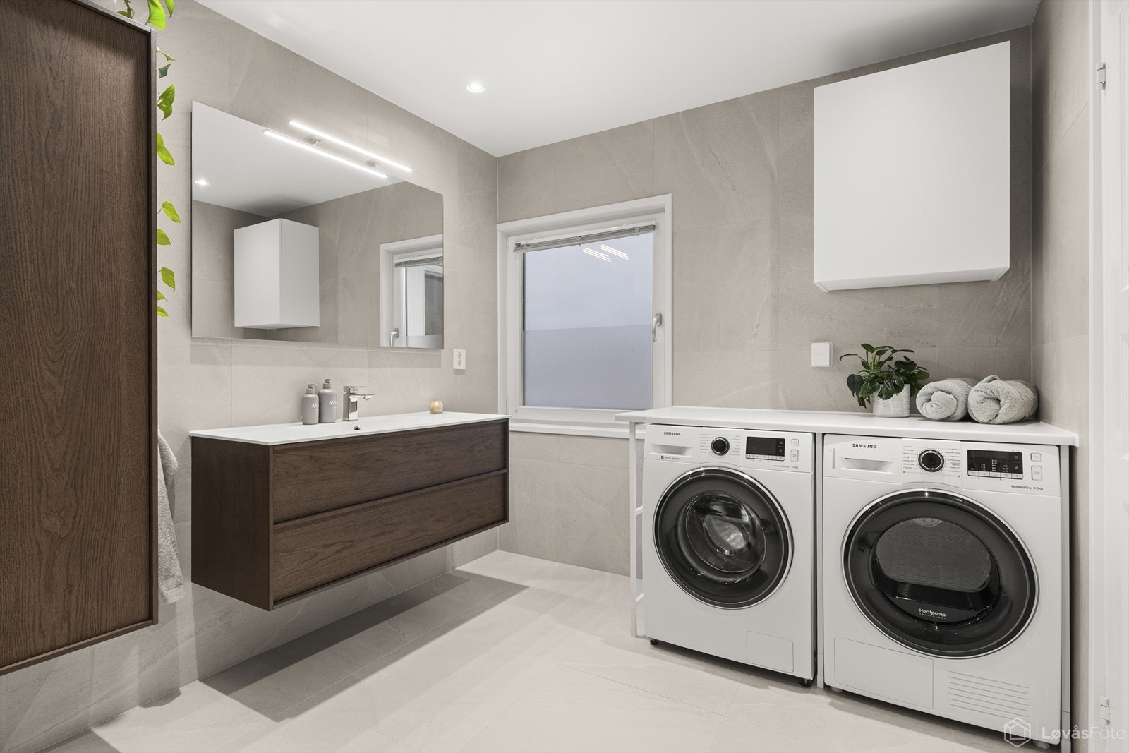 Elegant servantløsning med god oppbevaringsplass, speil med integrert belysning og moderne overflater. Galleribilde