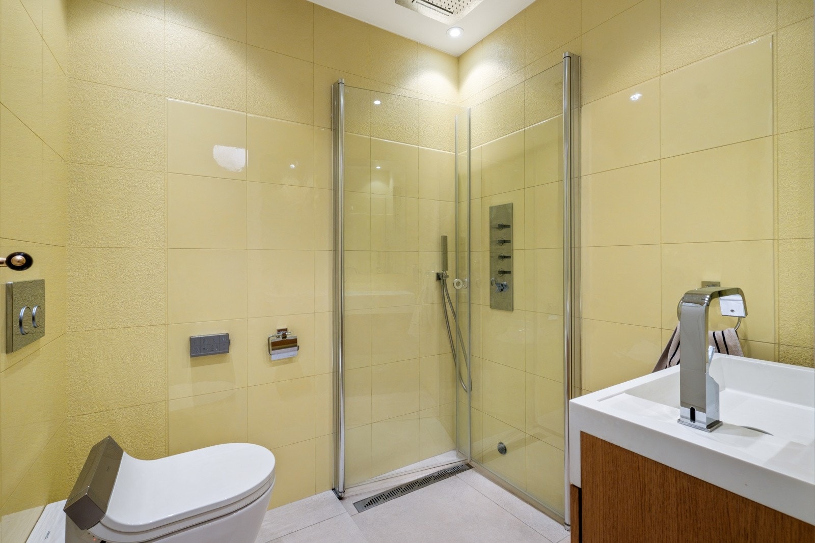 Baderommet er innredet med vegghengt toalett, servant, speil og dusjhjørne. Galleribilde