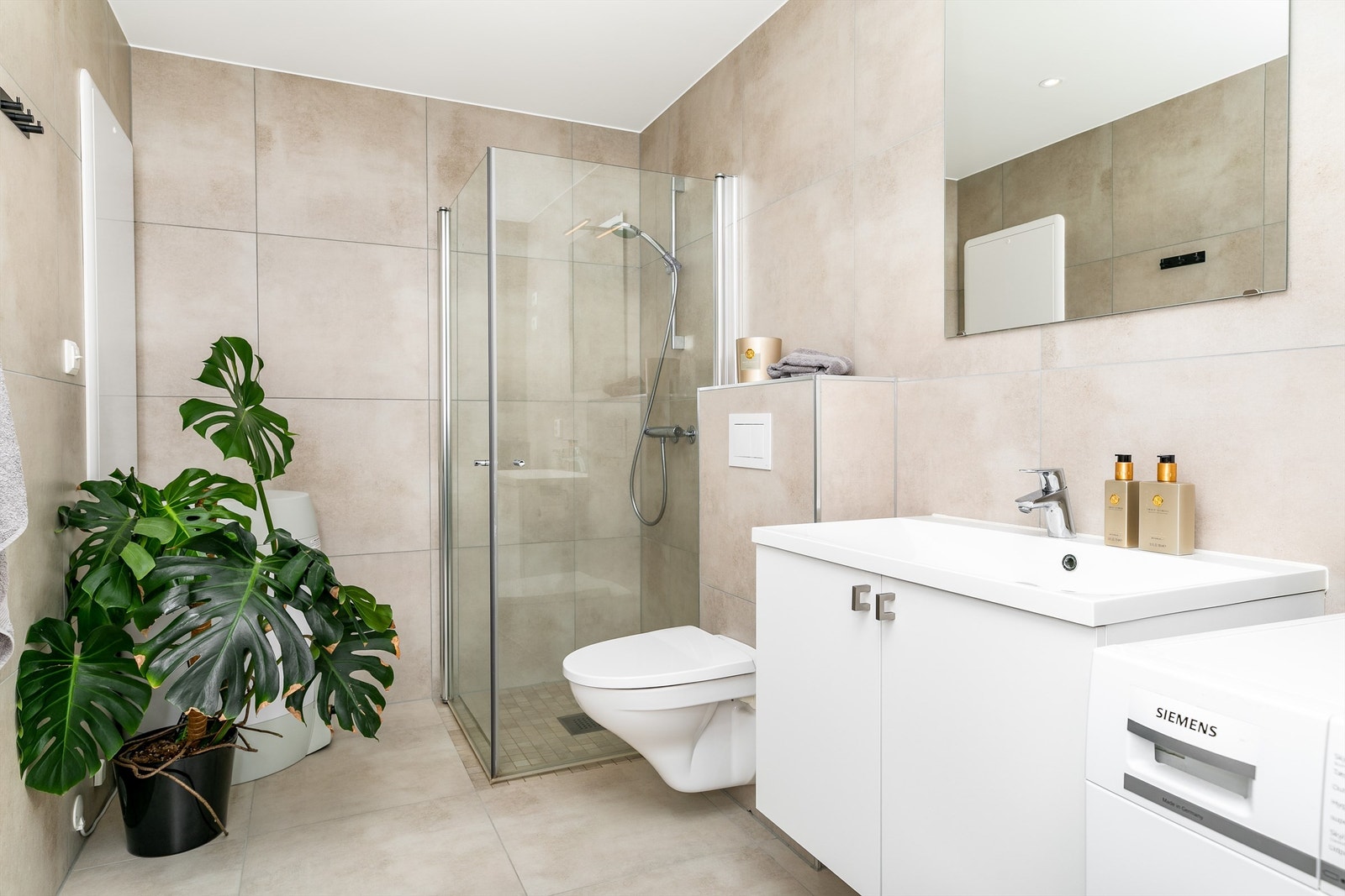 Like fliser av storformat i varme nyanser på gulv og vegger gir et helhetlig uttrykk. I gulvet er det naturligvis også varme. Galleribilde