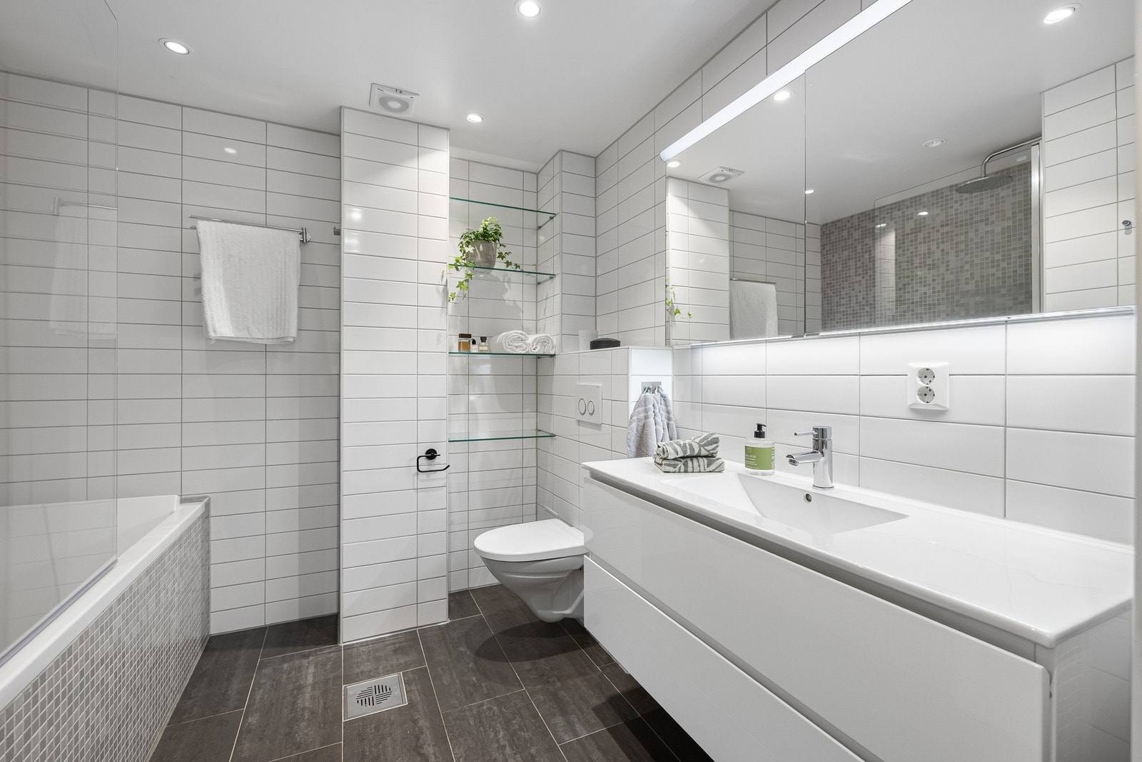 Badet er innredet med badekar, dobbeltservant og egen nisje for vaskesøyle. Galleribilde