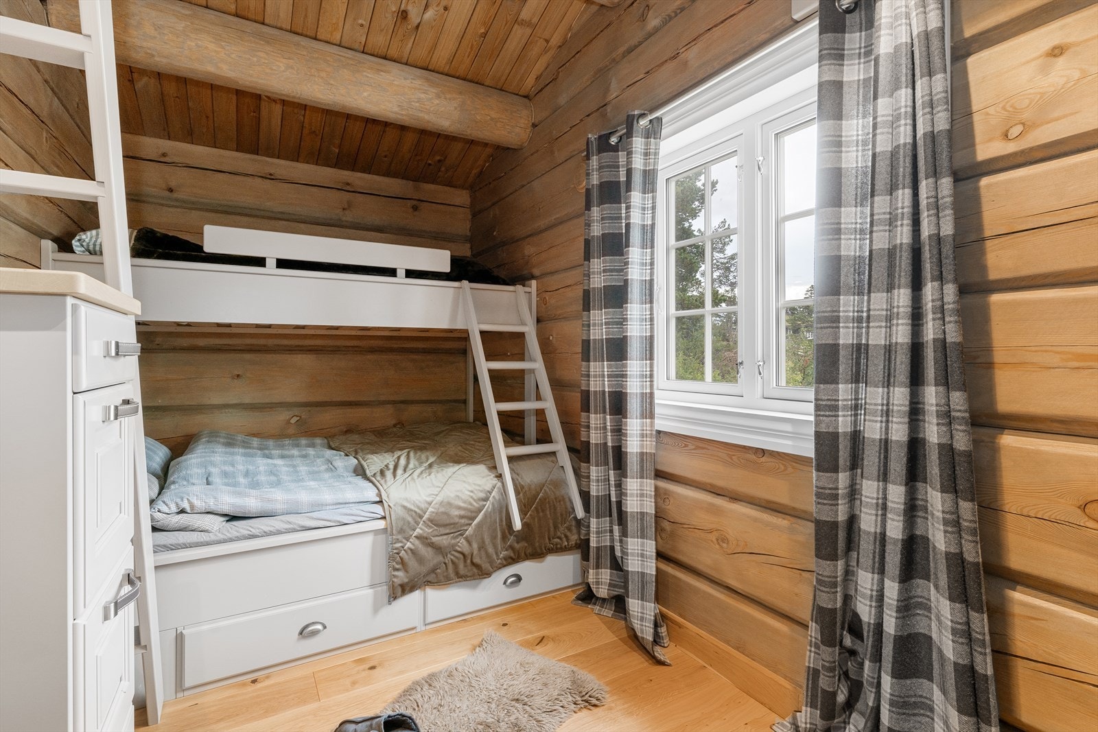 Soverom med plassbygd køyeseng med skuffer under sengen for god plass til oppbevaring. Soverommet har også hems. Galleribilde