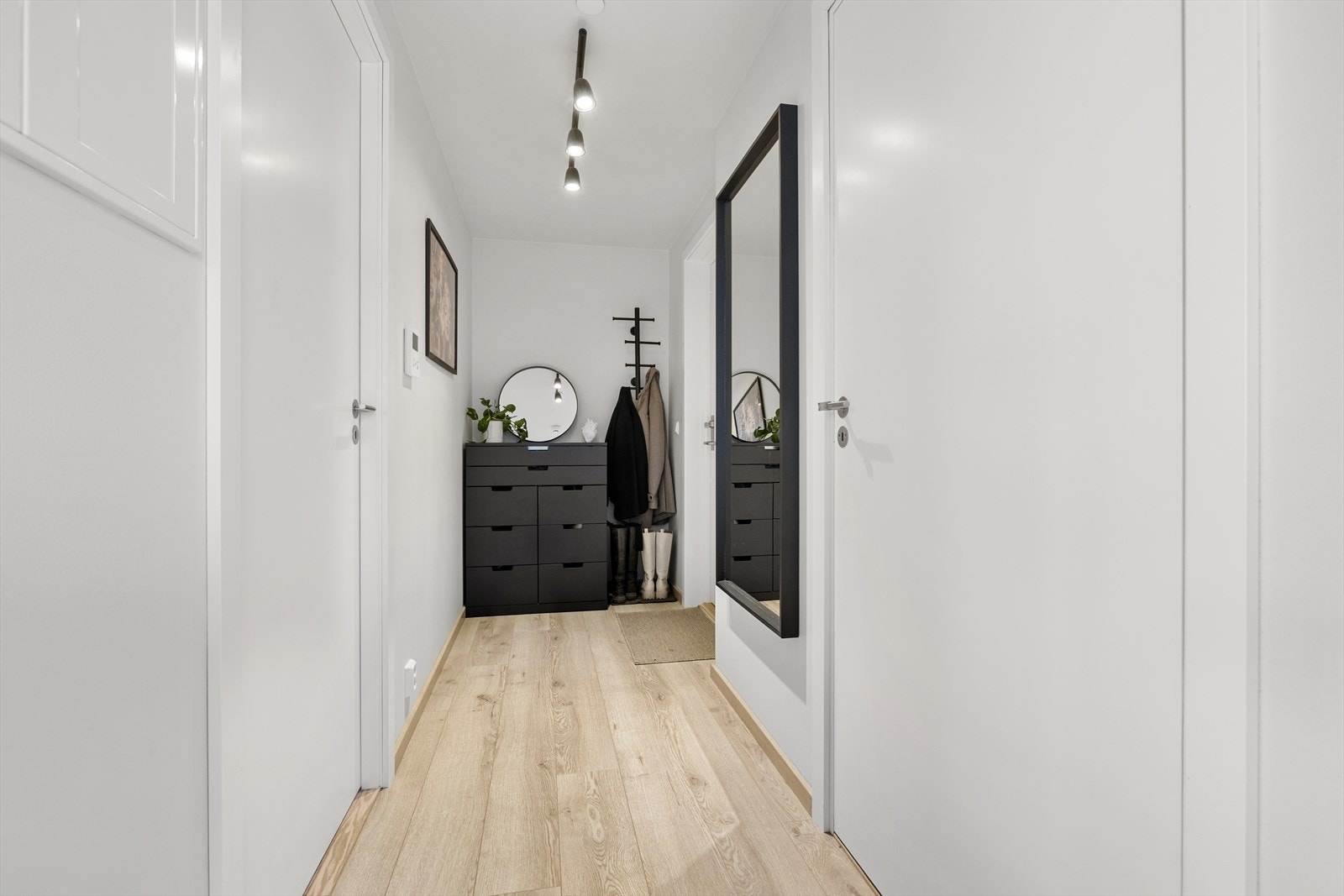 Praktisk entré med adkomst til alle boligens rom og plass til kommode til oppbevaring av sko og oppheng av klær. Galleribilde