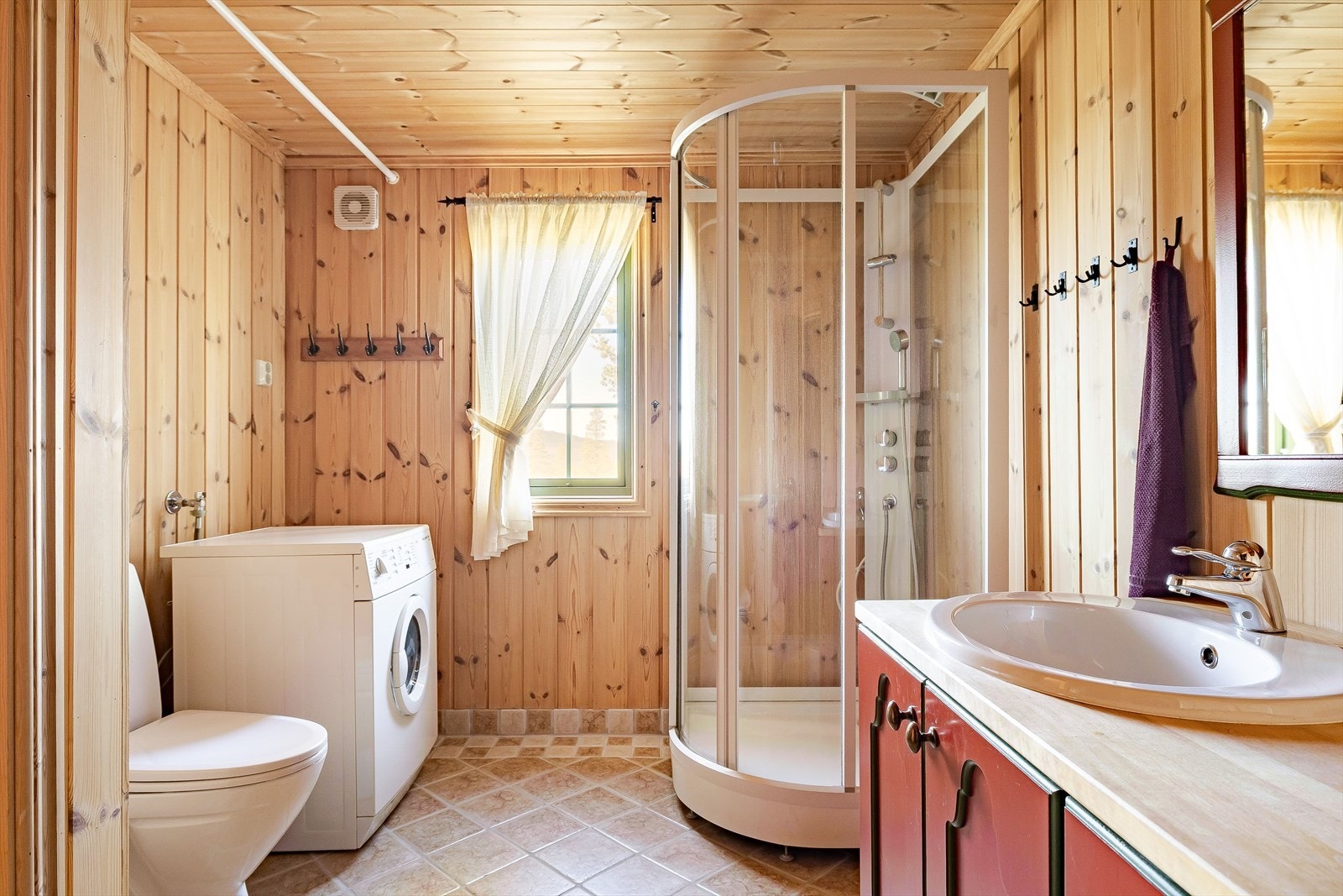 Baderommet har flislagt gulv med varmekabler og vegger med sokkelflis og panel samt opplegg til vaskemaskin. Galleribilde