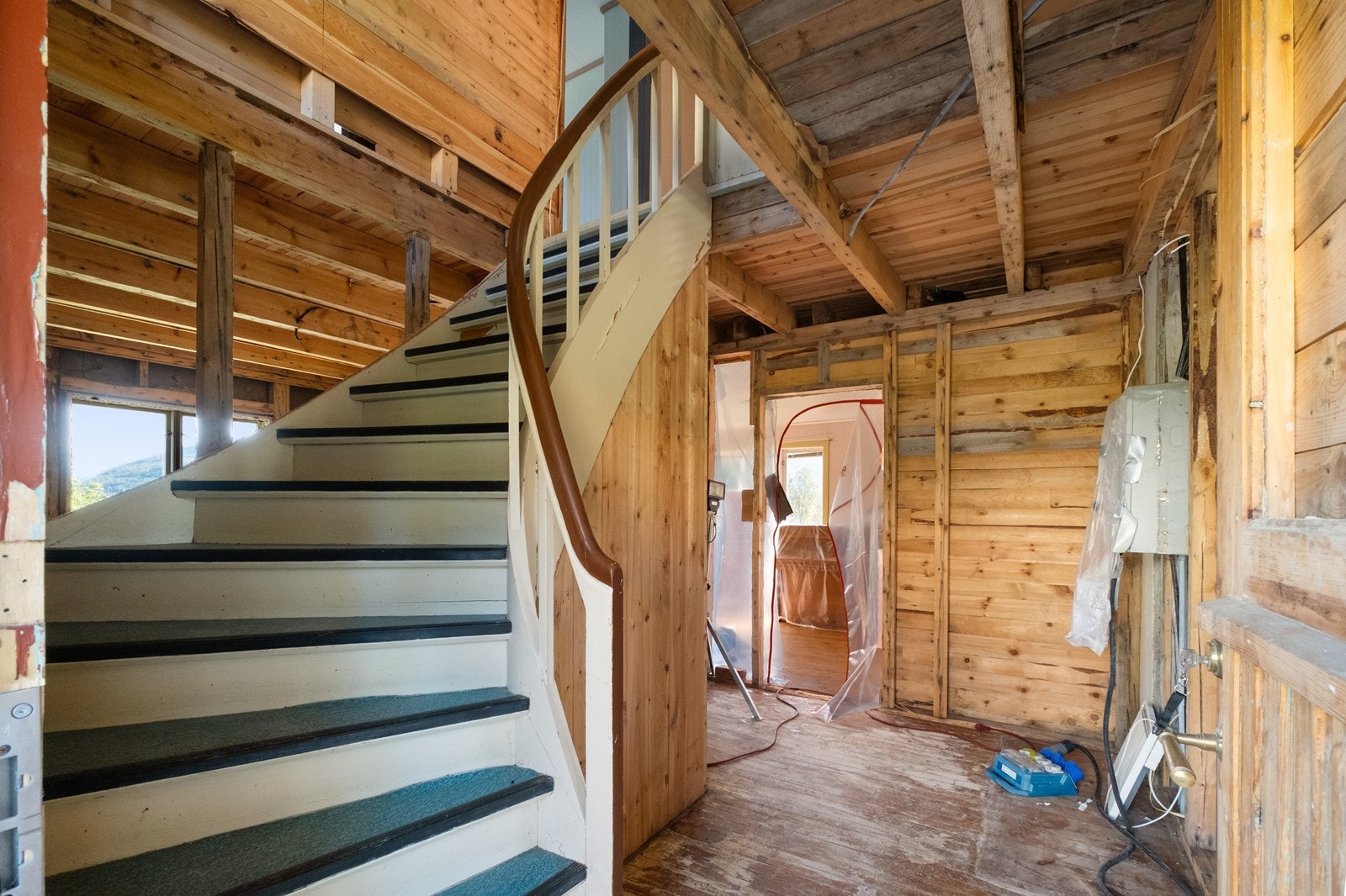 Åpen konstruksjon med synlig bindingsverk preger deler av interiøret. Tretrappen gir tilgang til boligens øvre etasje og er en sentral del av rommet. Galleribilde