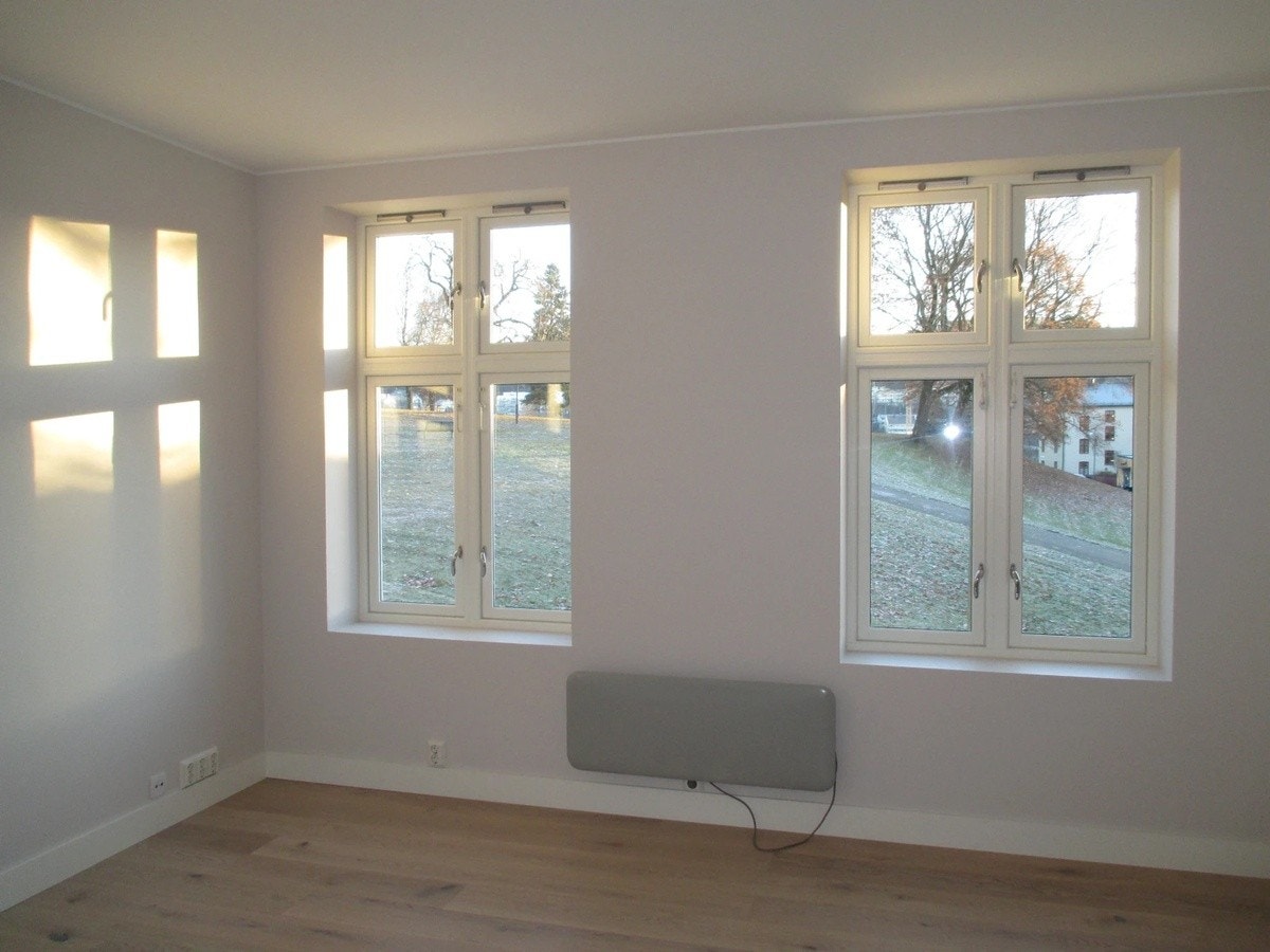 Stue med lyse store vinduer ut mot Vålerengaparken Galleribilde