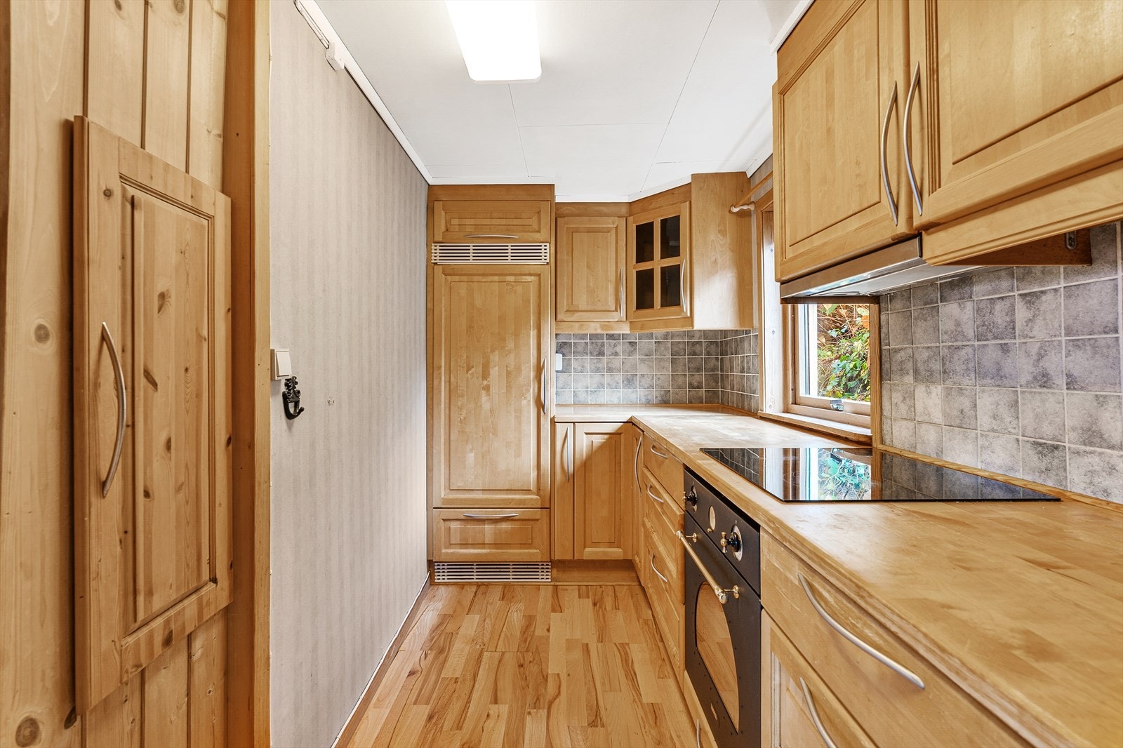 Kjøkkenet er utstyrt med integrerte hvitevarer, inkludert kjøleskap, oppvaskmaskin, platetopp og stekeovn. Galleribilde