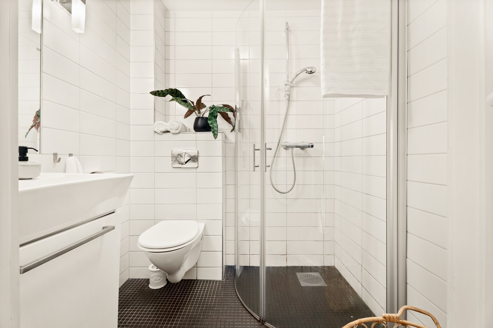 Moderne bad som er pusset opp i (ca.) 2013 med flislagte vegger, dusjhjørne og vegghengt toalett. Galleribilde