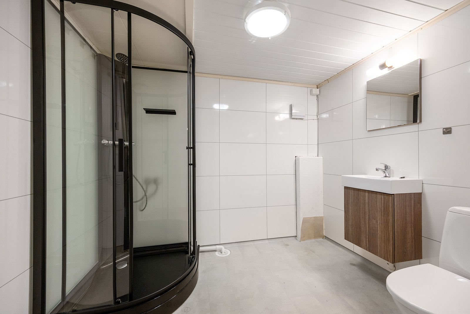 Rom i kjelleren som er innredet som baderom med servant i servantskap, dusjkabinett og toalett. Galleribilde