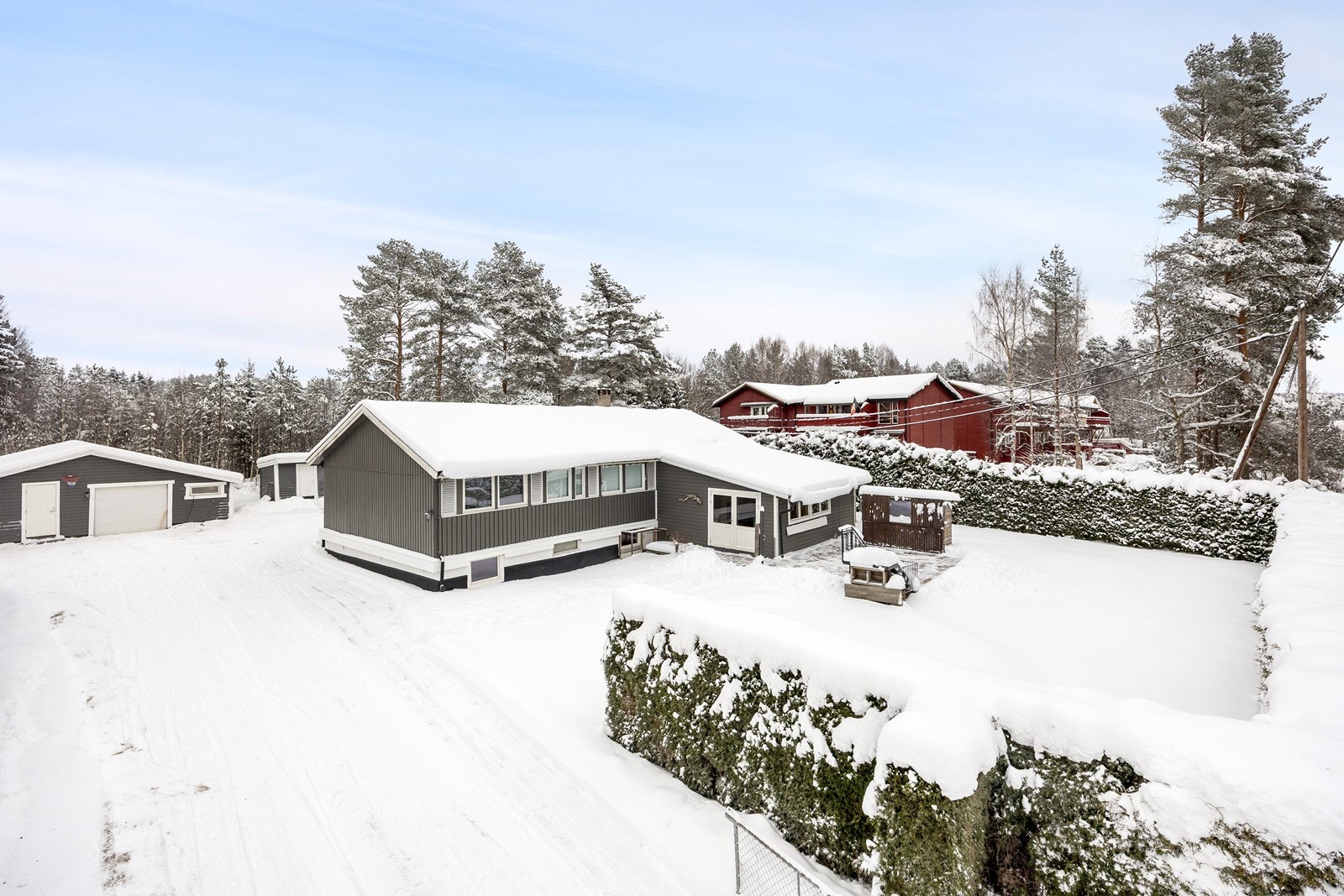 Det er opparbeidet hage rundt boligen med plen og hekk. Galleribilde