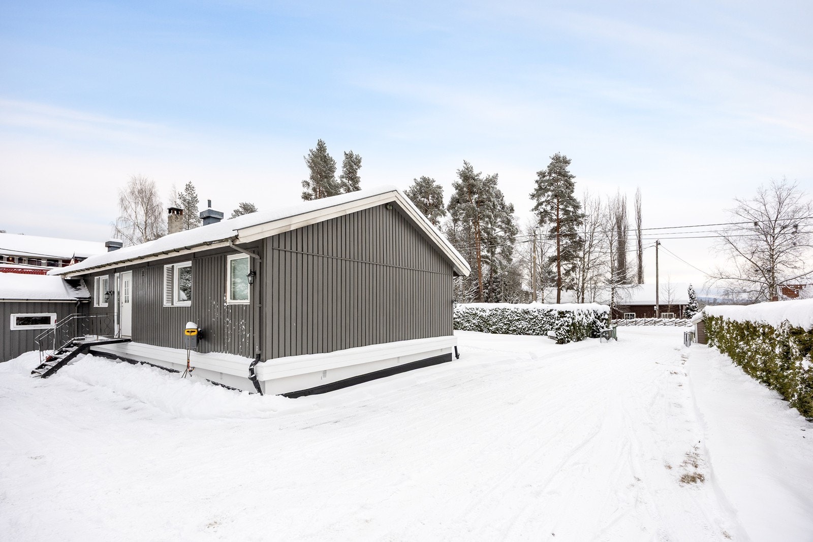 Fasade. Det er asfaltert gårdsplass og innkjørsel til boligen. Egen adkomst til hver etasje. Galleribilde