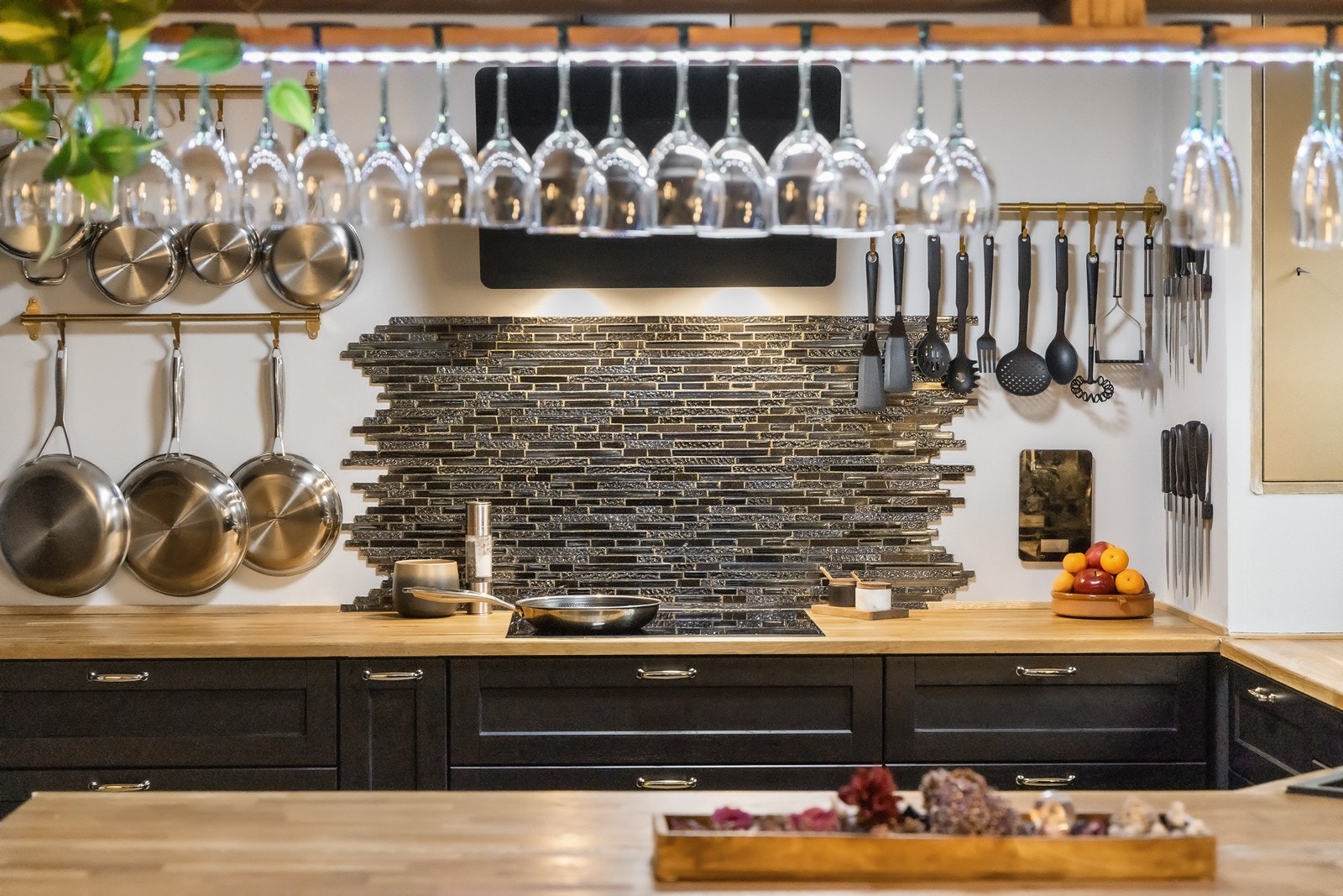 Over kokesonen har kjøkkenet stilige fliser og sort ventilator. Galleribilde