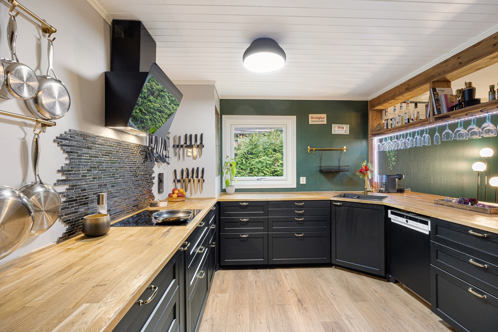 Innredningen har en funksjonell u-form med sorte, profilerte fronter og heltre benkeplate med oppvaskkum i kompositt. Galleribilde