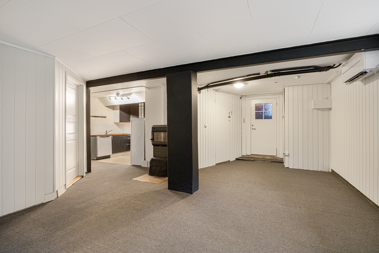 Kjelleren har egen adkomst. Rommet har vedovn og varmepumpe. Galleribilde