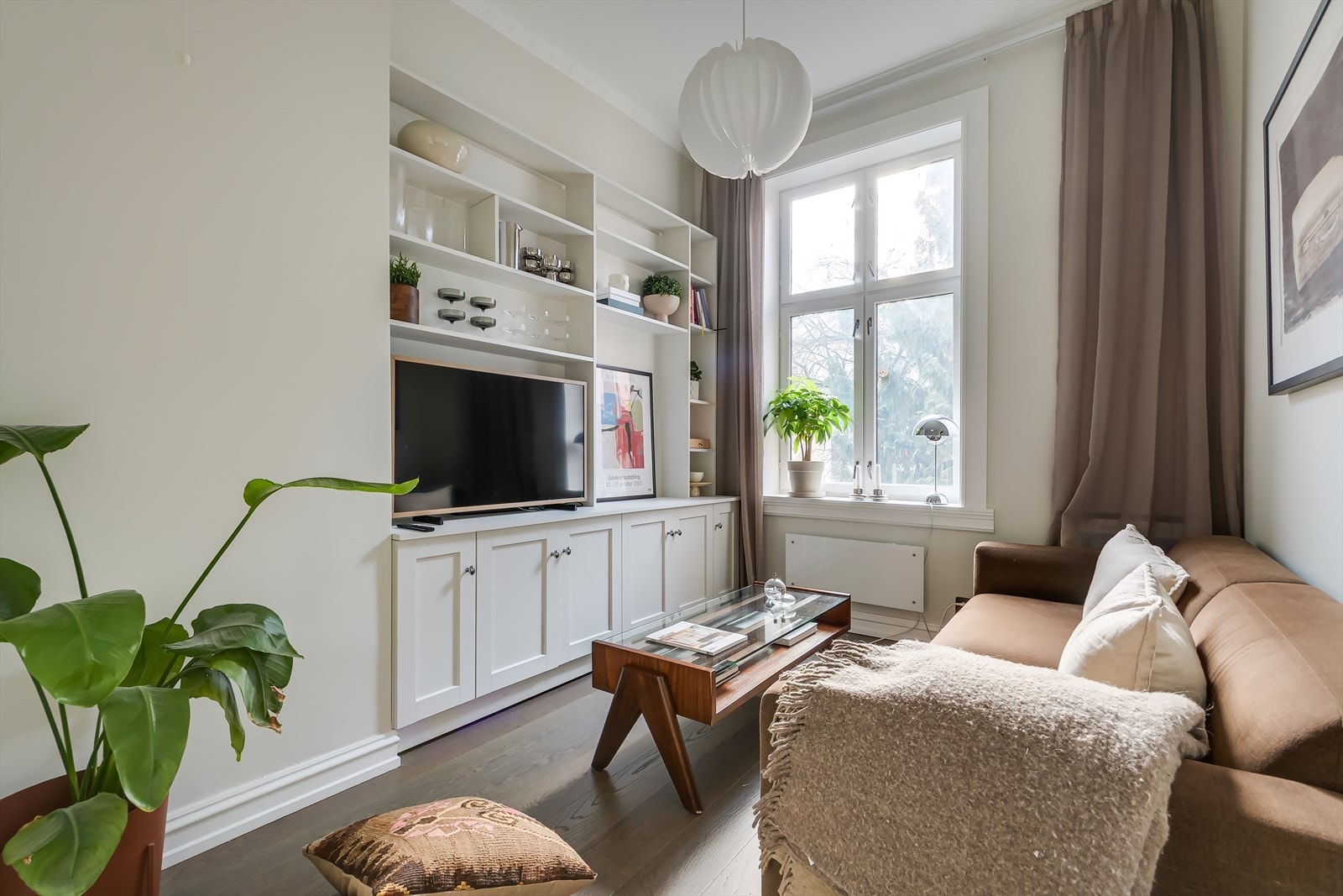 Dagens stueløsning med koselig tv del og plassbygde hyller - Det er åpning bak hylleløsning til soverommet dersom ny eier ønsker å åpne opp Galleribilde