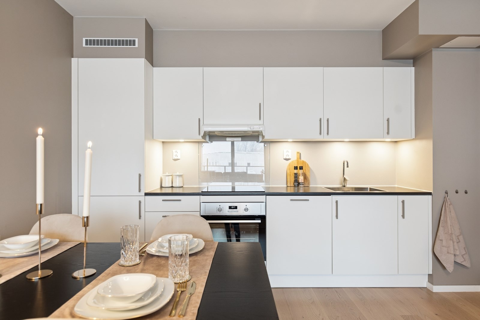 Kjøkkenet er innredet med glatte, moderne fronter og en praktisk laminatbenkeplate. Oppvaskkummen i stål gir et stilrent og funksjonelt preg. Galleribilde