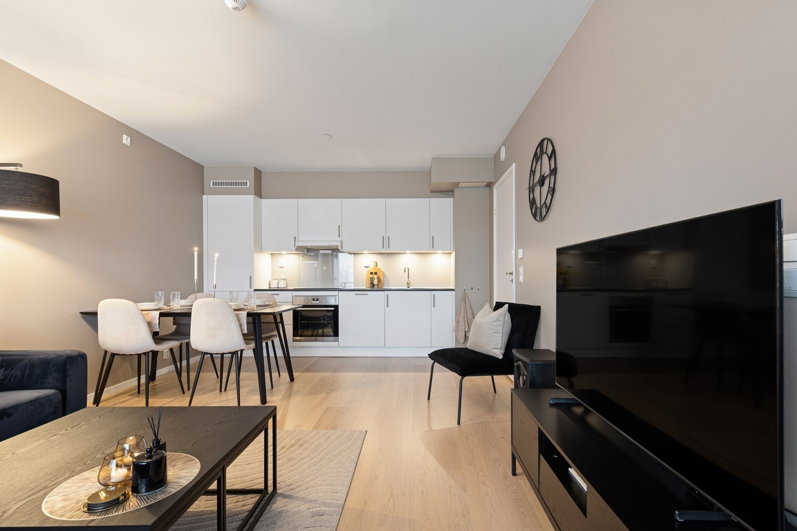 Den åpne løsningen mellom stue og kjøkken gir en harmonisk og praktisk romfølelse, perfekt for sosiale sammenkomster med venner og familie. Galleribilde