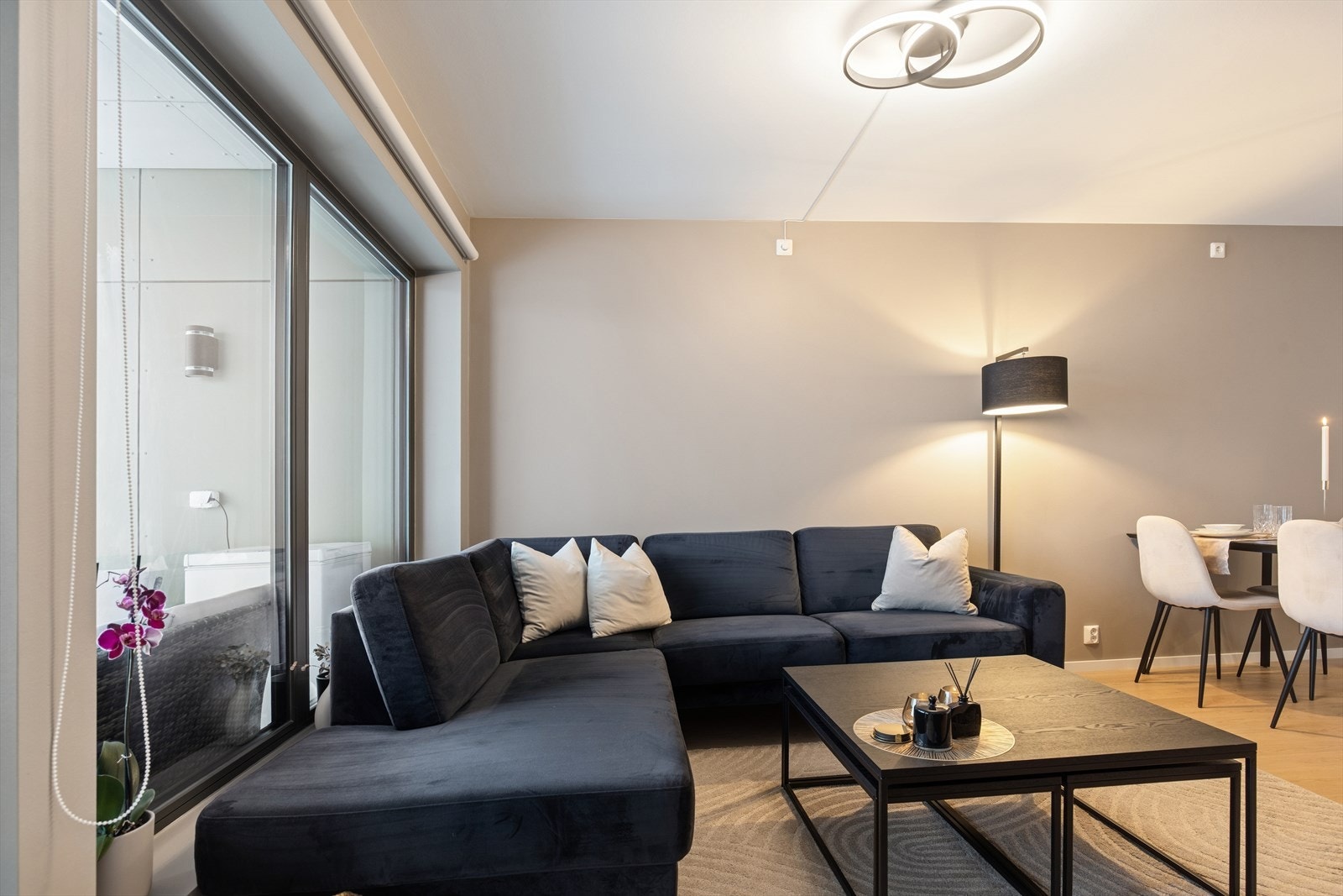 De store vindusflatene slipper inn rikelig med dagslys og gir rommet en luftig atmosfære. Her er det god plass til både en komfortabel sofagruppe, spiseplass og et hyggelig TV-hjørne. Galleribilde