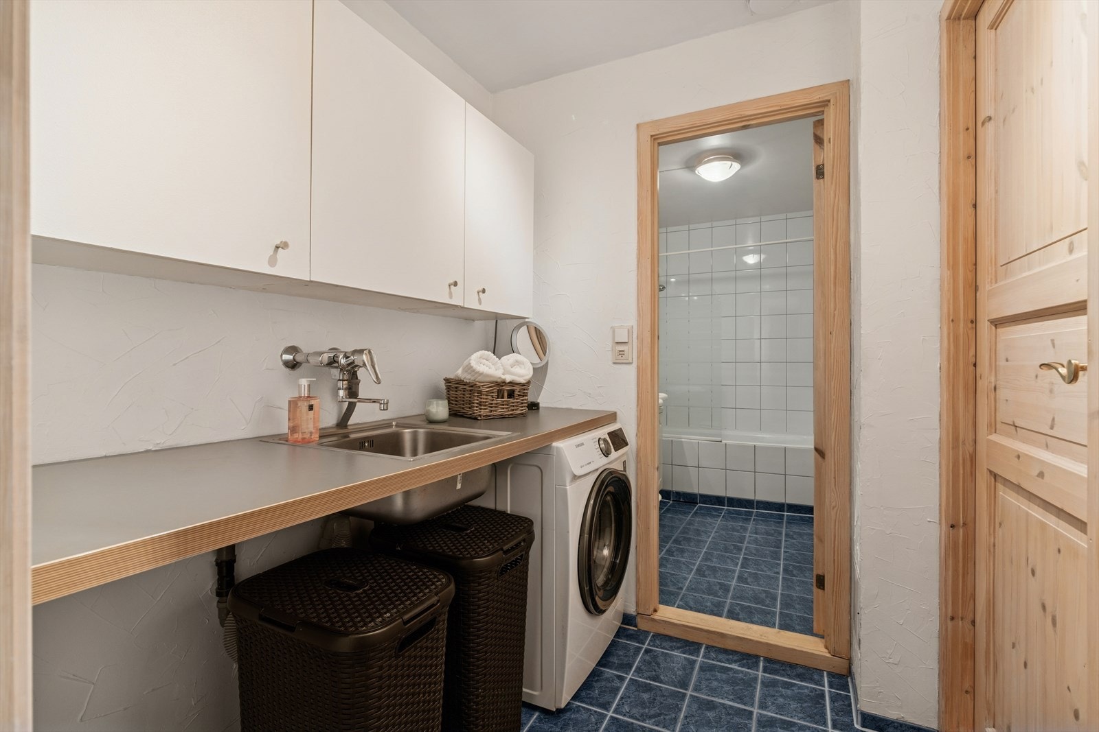 Vaskerom i tilknytning til badet innredet med benkeplate i laminat, nedfelt utslagsvask, overskap samt opplegg for vaskemaskin. Oppgradert med overflater og innredning i 1994. Det er varmekabler i gulv Galleribilde