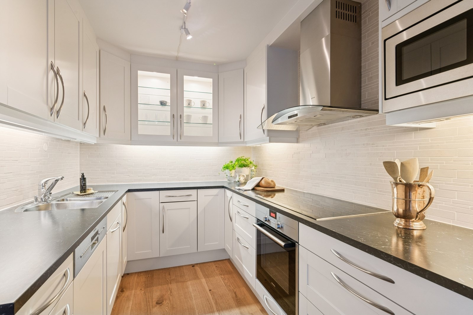 Kjøkkenet har integrerte hvitevarer som oppvaskmaskin, stekeovn, koketopp, mikro og kjøleskap med fryser Galleribilde